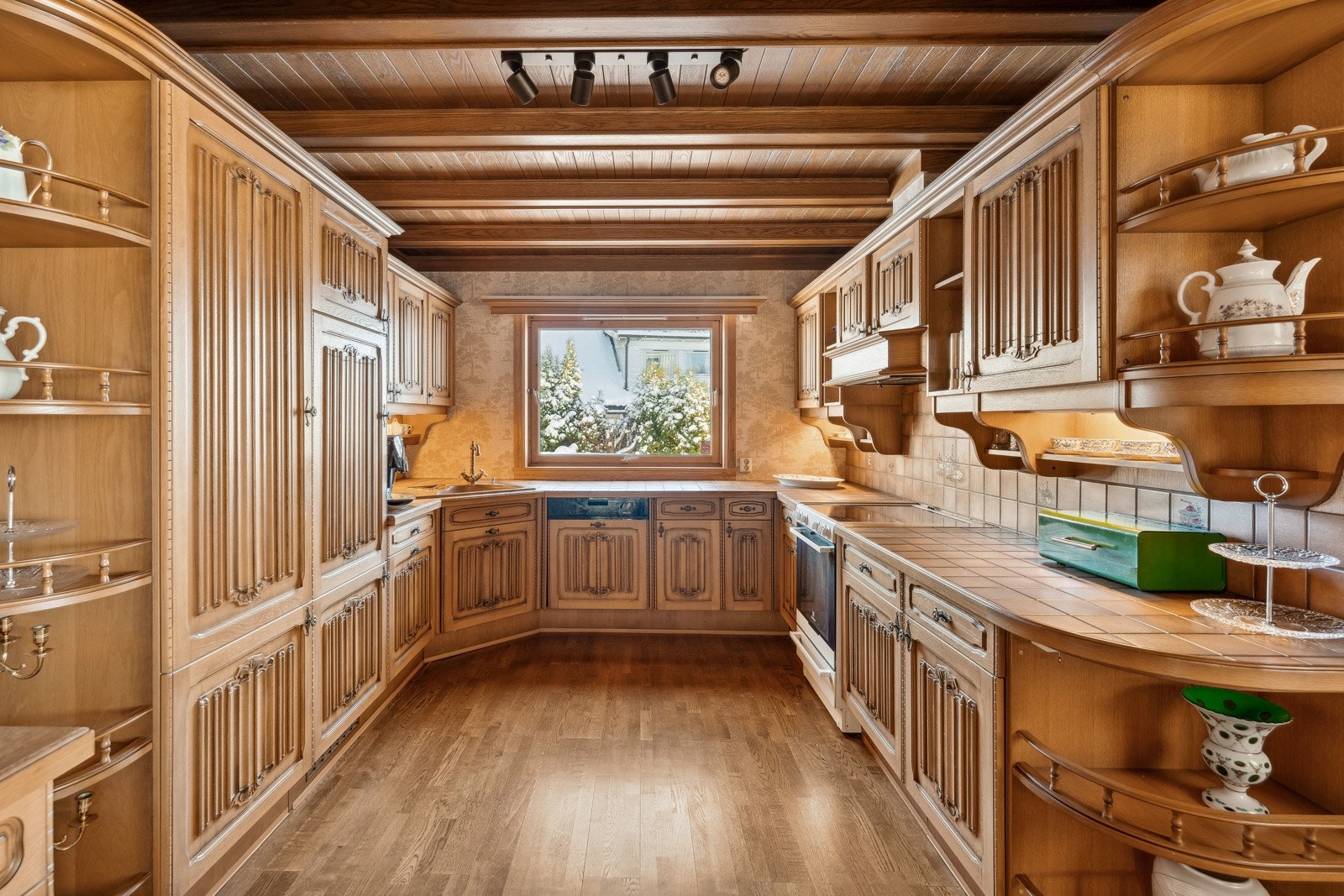 Innredningen har u-form og byr rikelig med skap- og benkeplass. Det er fliser mellom over- og underskap, samt på benkeplaten. Galleribilde