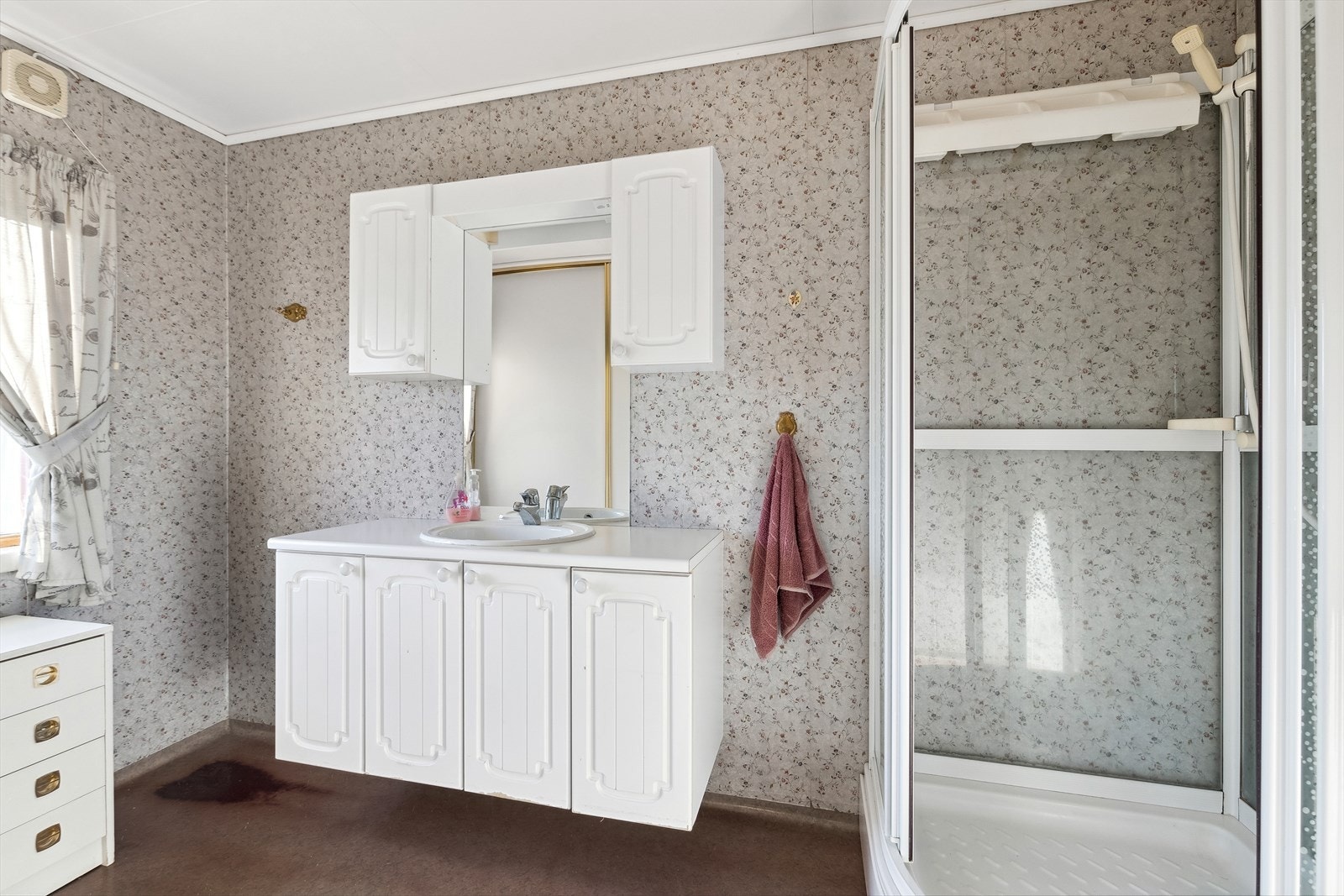 Baderommet er innredet med et dusjkabinett og seksjon med servant. Galleribilde