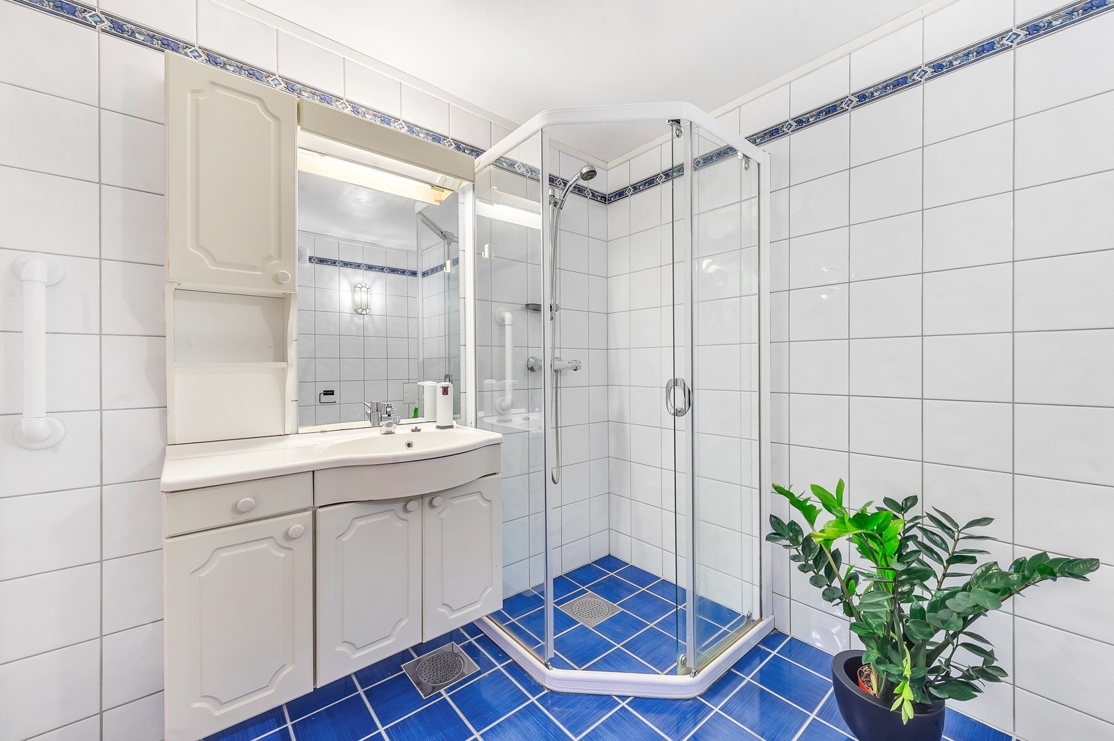 Badet er utstyrt med baderomsinnredning med servant, speil, lys, dusjhjørne med glassdører og gulvstående toalett. Det er også opplegg for vaskemaskin. Galleribilde