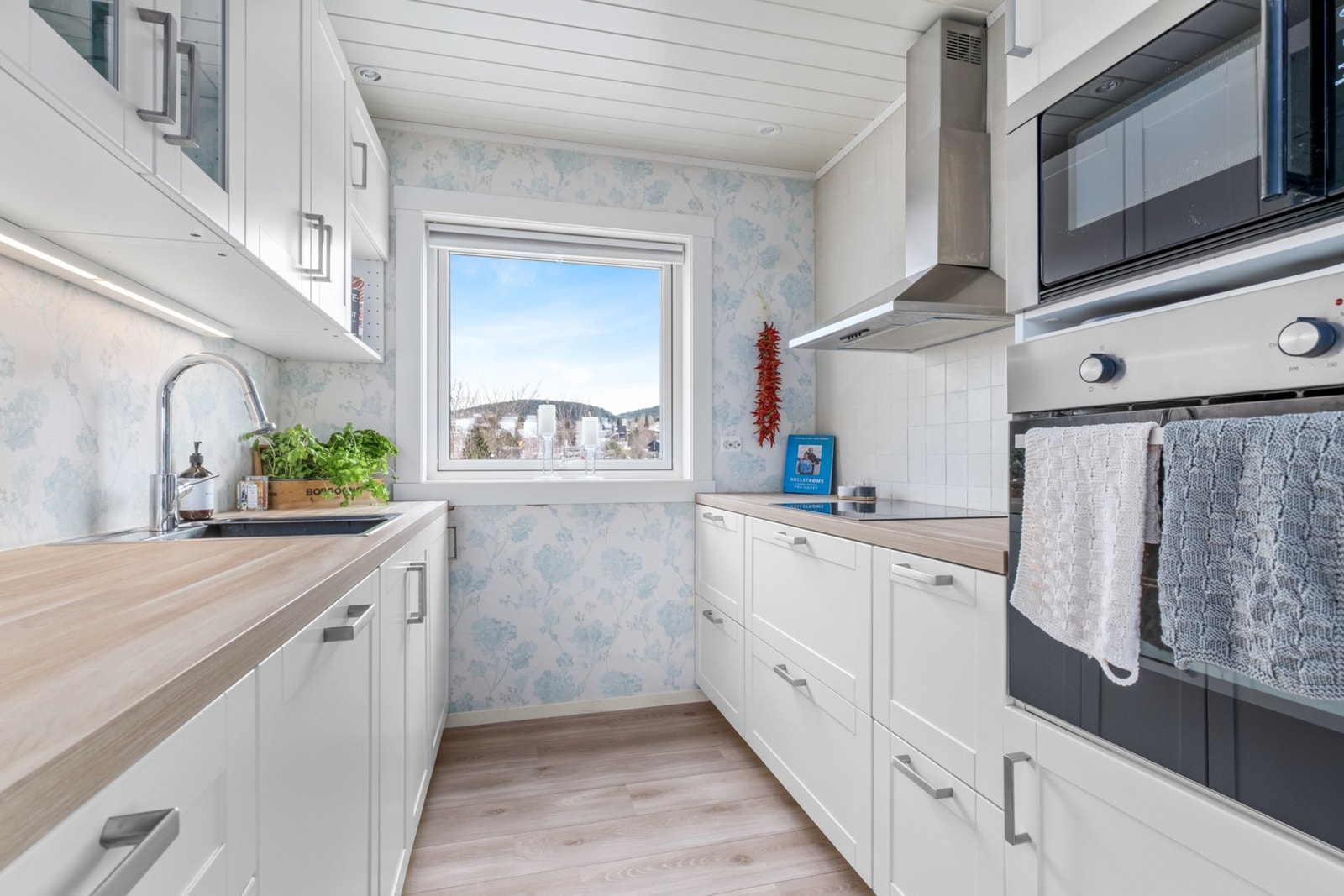 Lyst og pent kjøkken med rikelig med skap- og benkeplass. Galleribilde