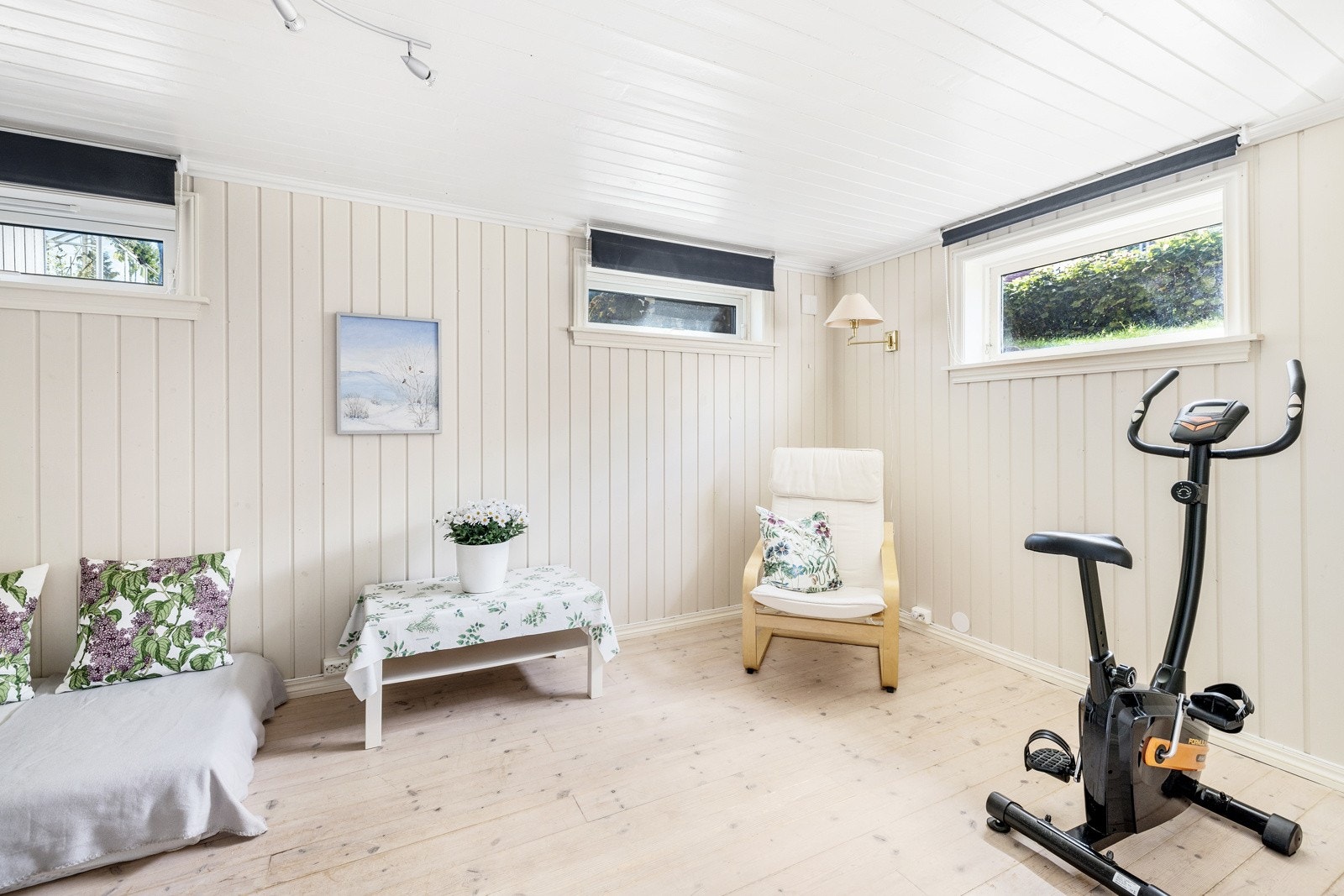 Kjellerstuen har et trivelig preg med lyst gulv, lysmalte panelvegger og høytsittende vinduer. Galleribilde