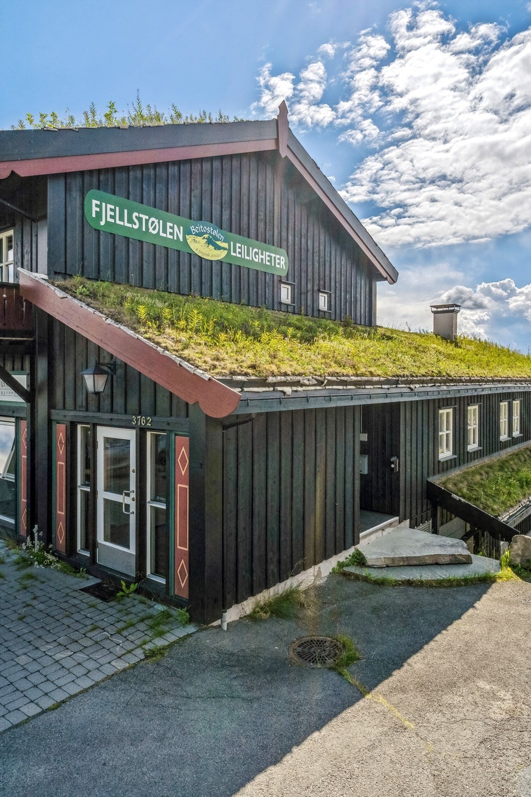 Fra inngangsparti på enden av bygget, det er to innganger til denne leiligheten fra bakkeplan. Galleribilde