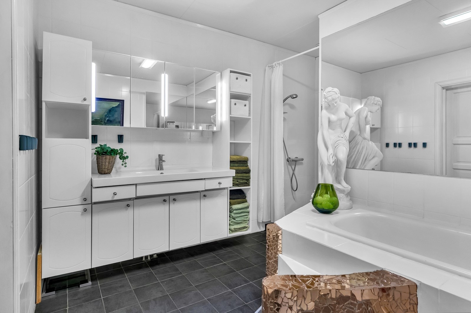 Innredning med profilerte fronter og heldekkende servant med overskap m/ speil og lys. Galleribilde