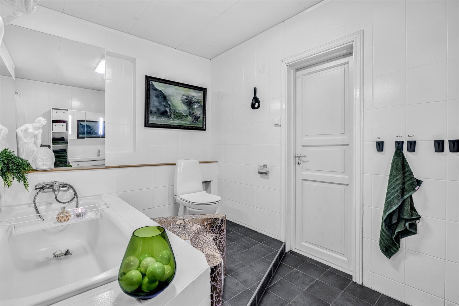 Badet har gulvmontert klosett og innmurt badekar. Galleribilde