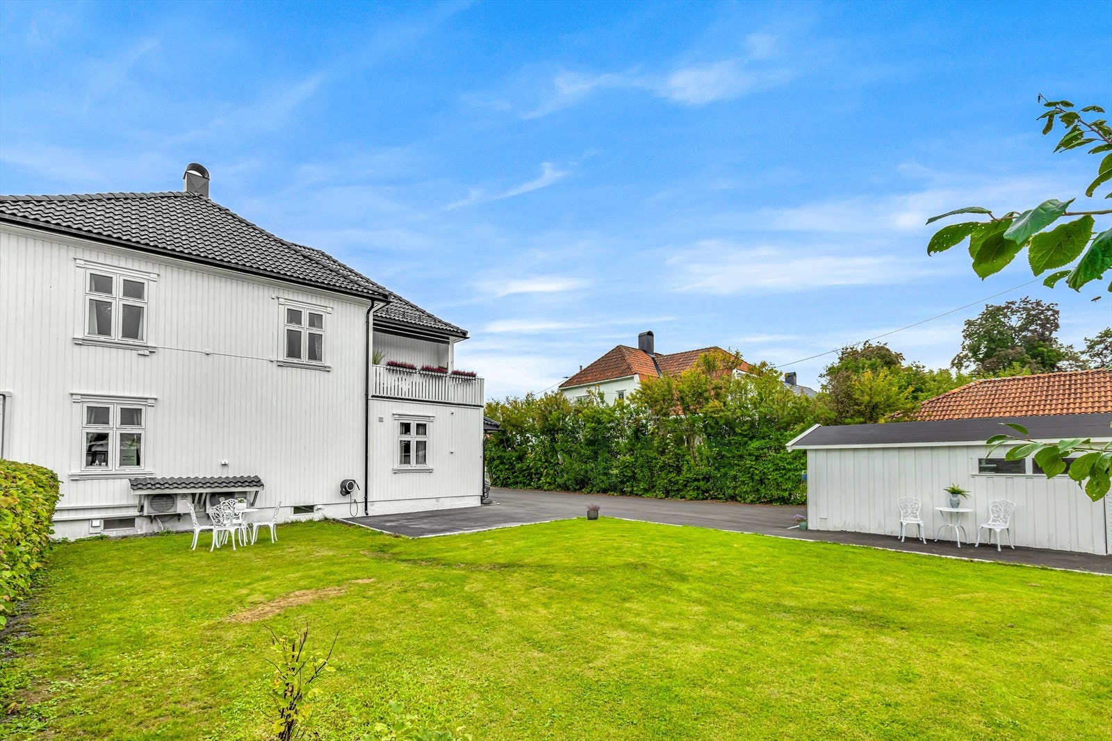 Pent opparbeidet hage med plen, prydusker og fruktrær. Galleribilde