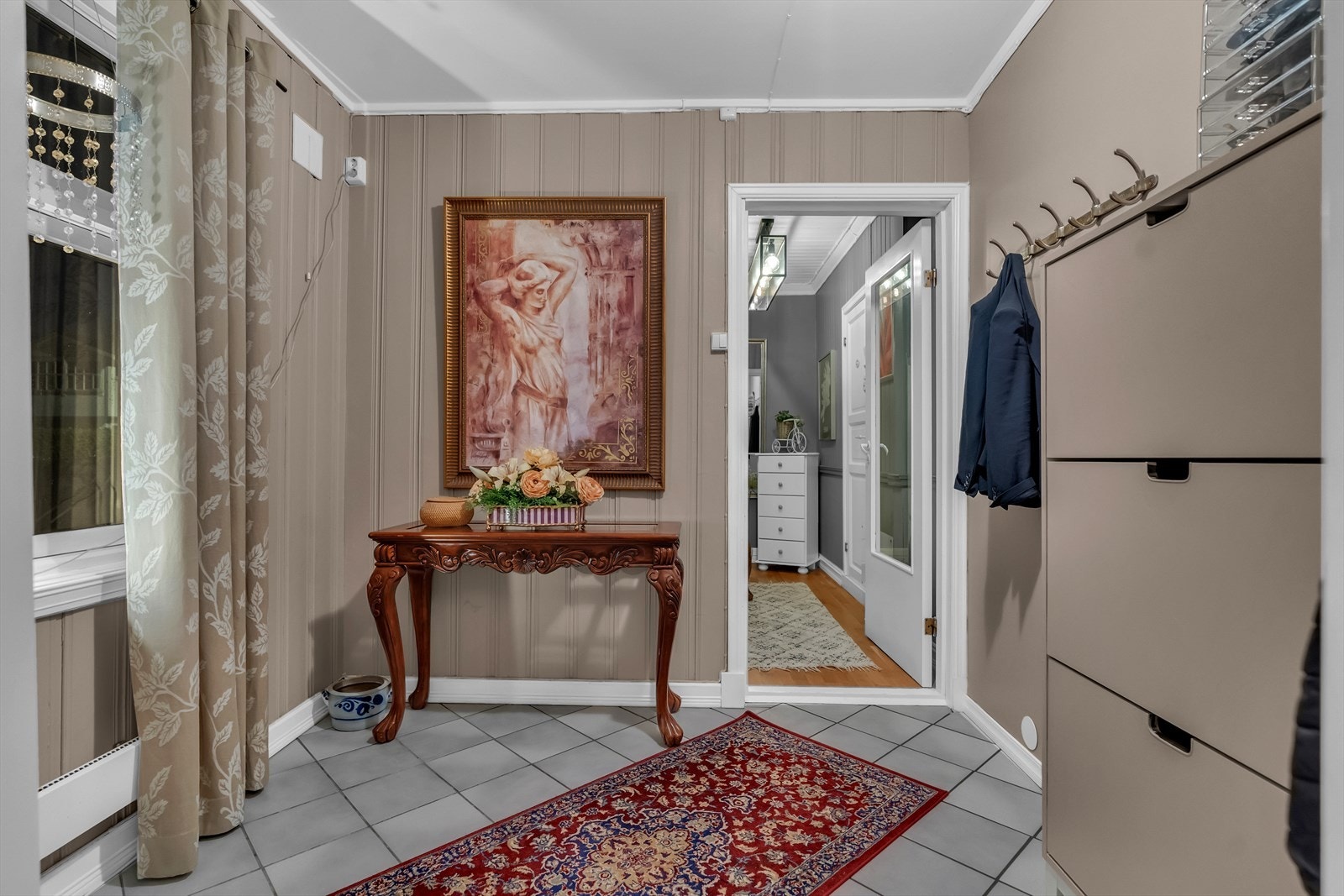 Romslig entré med fliser på gulvet. Galleribilde