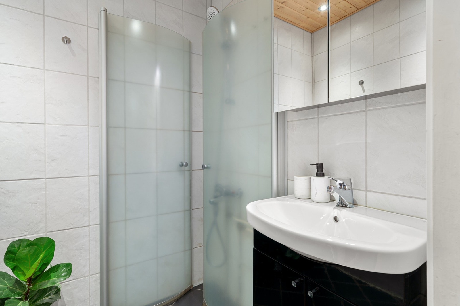 Badet er fra 2010 og har flis på vegger og panel med spotter i himling. Galleribilde