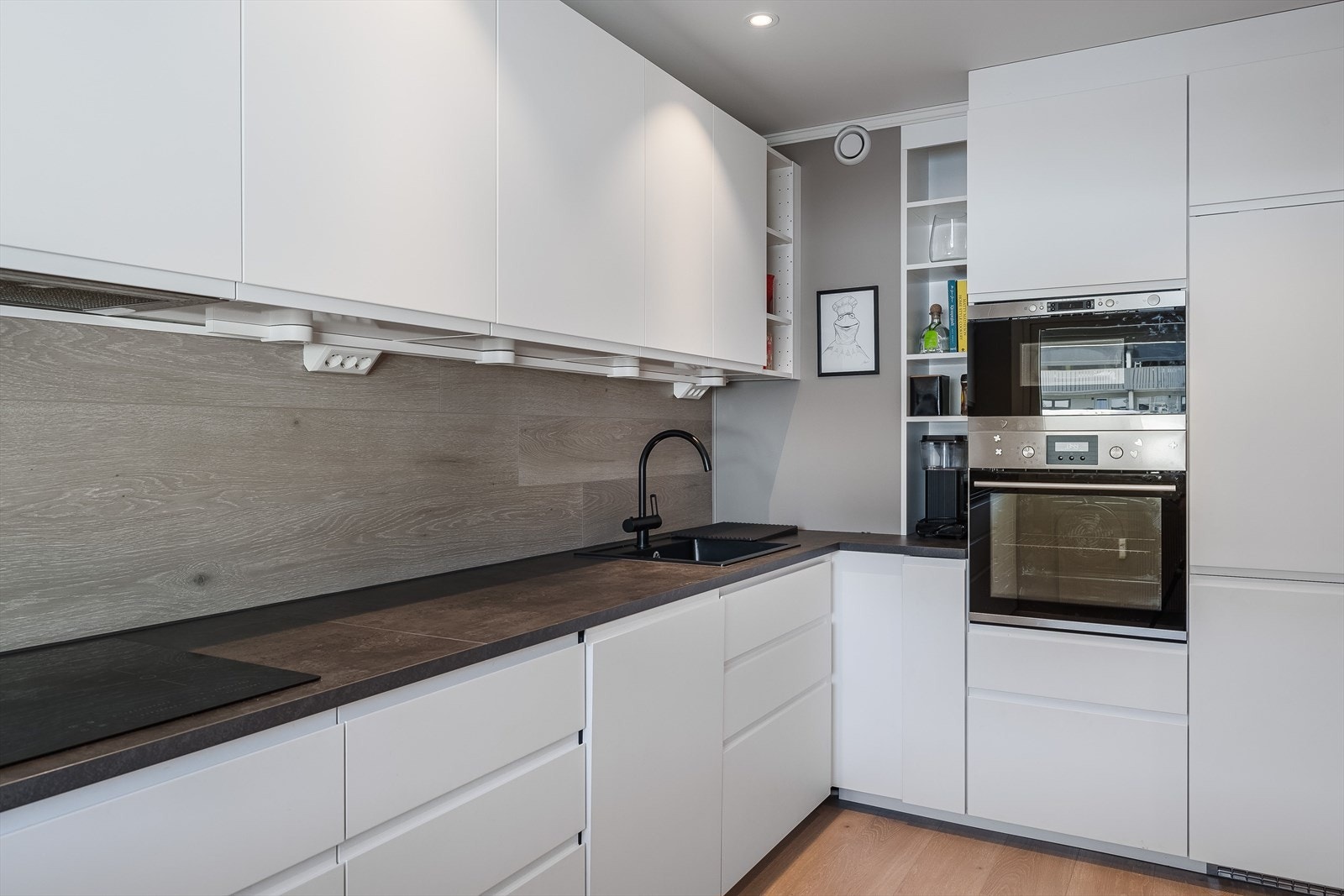 Kjøkkenet er pusset opp i 2022 og har innredning fra IKEA. Innredningen består av over- under- og høyskap i laminerte skrog med hvite, glatte fronter. Det er laminerte benkeplater og kitchenboard i benkeryggen. Galleribilde