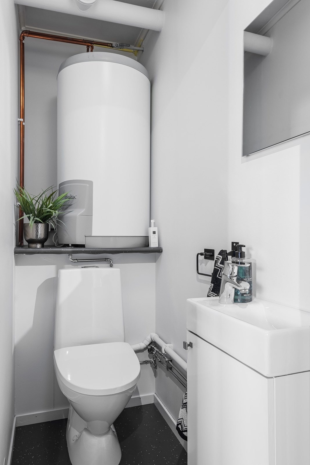 Vegg i vegg med badet er det separat toalettrom med gulvmontert toalett og servantskap med håndvask. Galleribilde