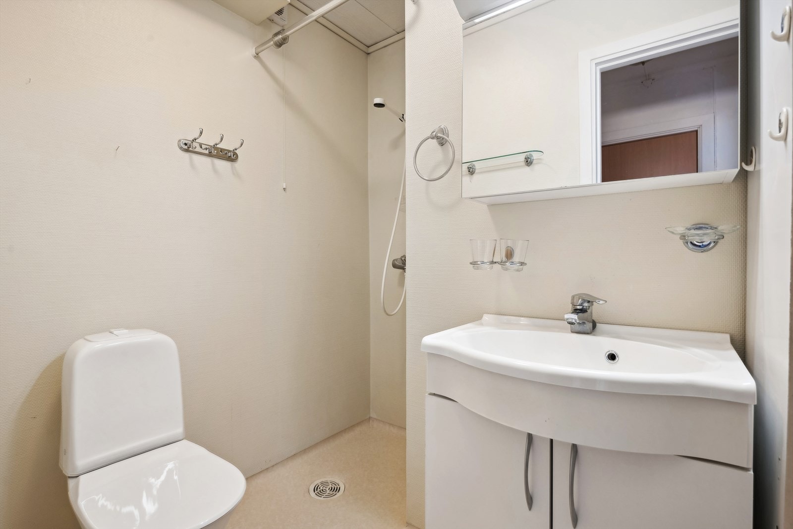 Det er gulvmontert wc, heldekkende servant med ett-greps blandebatteri på skapinnredning Galleribilde