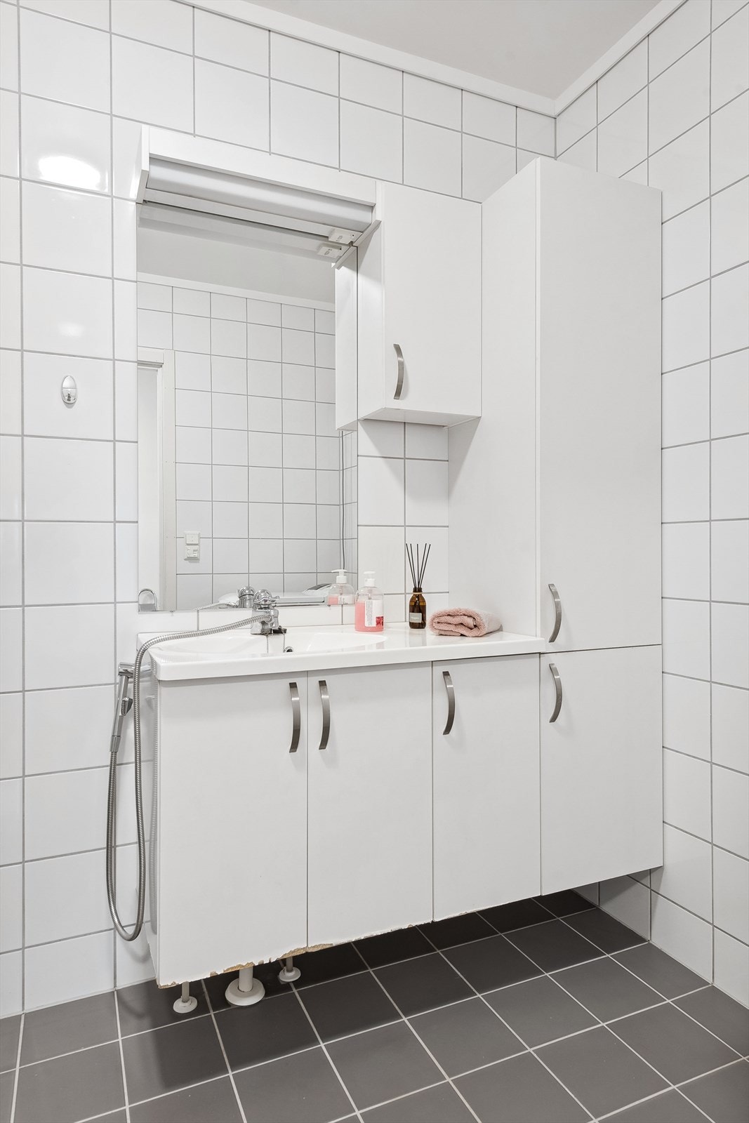 Badet er innredet med romslig vegghengt innredning med servant, speil og lys Galleribilde