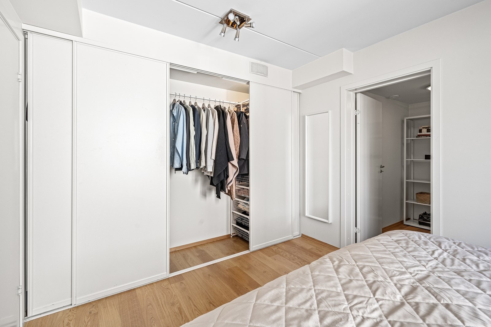 Det er montert stor skyvedørsgarderobe langs den ene veggen for oppbevaring av klær og annen lagring Galleribilde