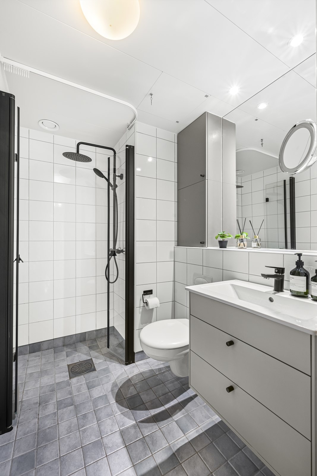 Pent flislagt baderom med elektrisk gulvvarme og opplegg for vaskemaskin. Galleribilde