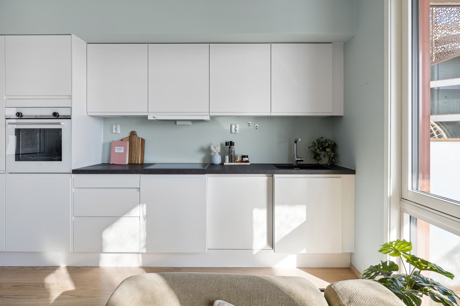 Lekkert kjøkken som har godt med skap - og benkeplass. Galleribilde