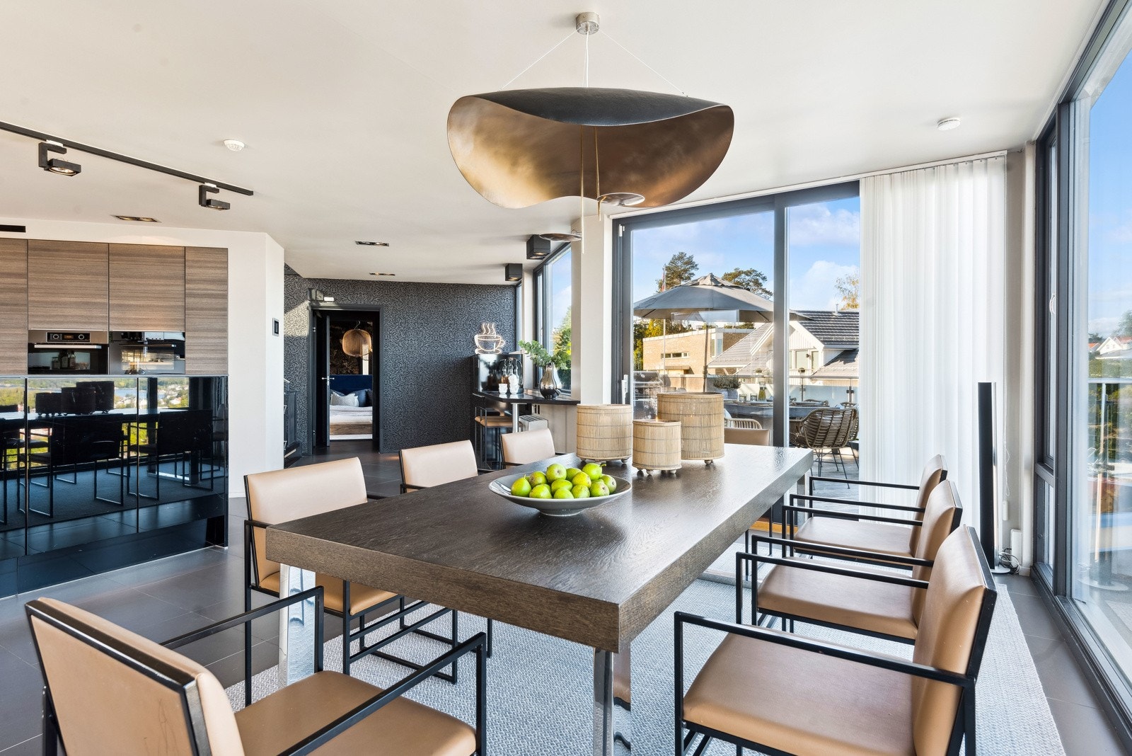 Den åpne løsningen gjør at gjestene rundt spisebordet får fin kontakt med hobbykokken på kjøkkenet. Galleribilde