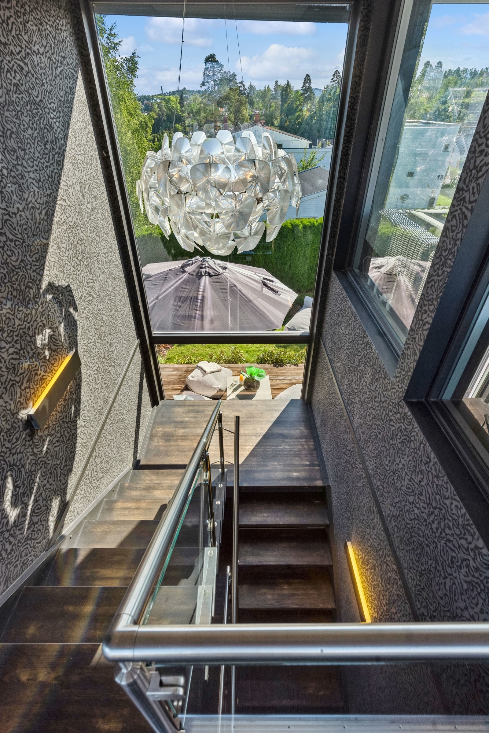 Trapperommet har store vindusflater og en lekker lampe. Trappen er i heltre og kan slipes. Galleribilde