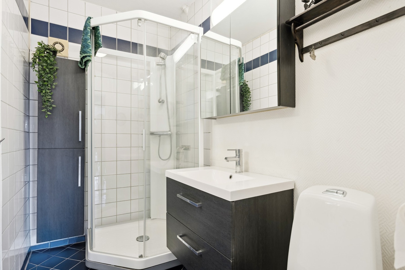 Bad med dusjkabinett, baderomsinnredning og speilskap. Galleribilde