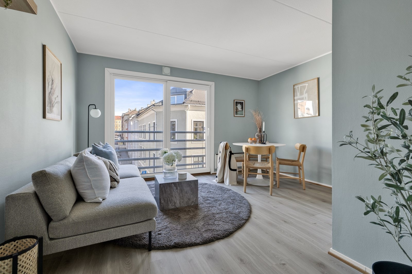 Stuen i leiligheten er romslig og flott opplyst med store vindusflater som gir rikelig med naturlig lys Galleribilde