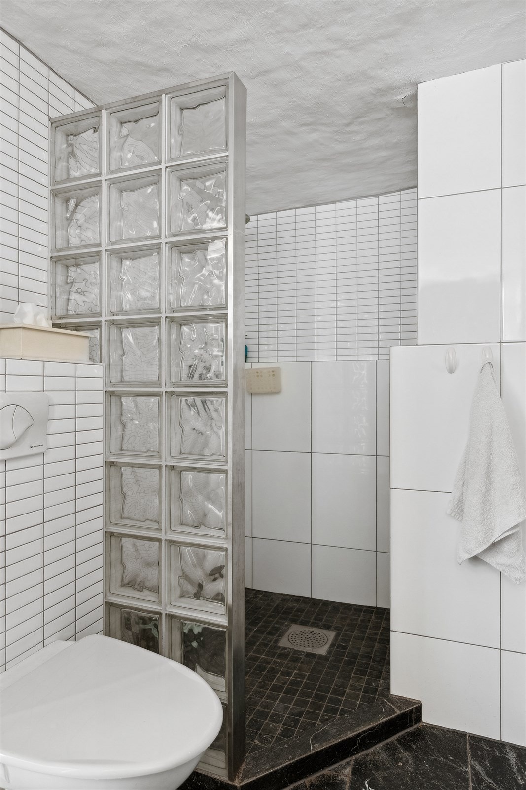 Rommet har veggmontert toalett, dusj, vask og opplegg for vaskemaskin. Det er naturlig ventilering. Galleribilde