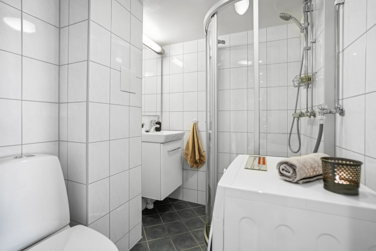 Praktisk og flislagt baderom med varmekabler som ble pusset opp i regi av borettslaget i 2012. I 2022 etablerte eier opplegg for vaskemaskin. Galleribilde