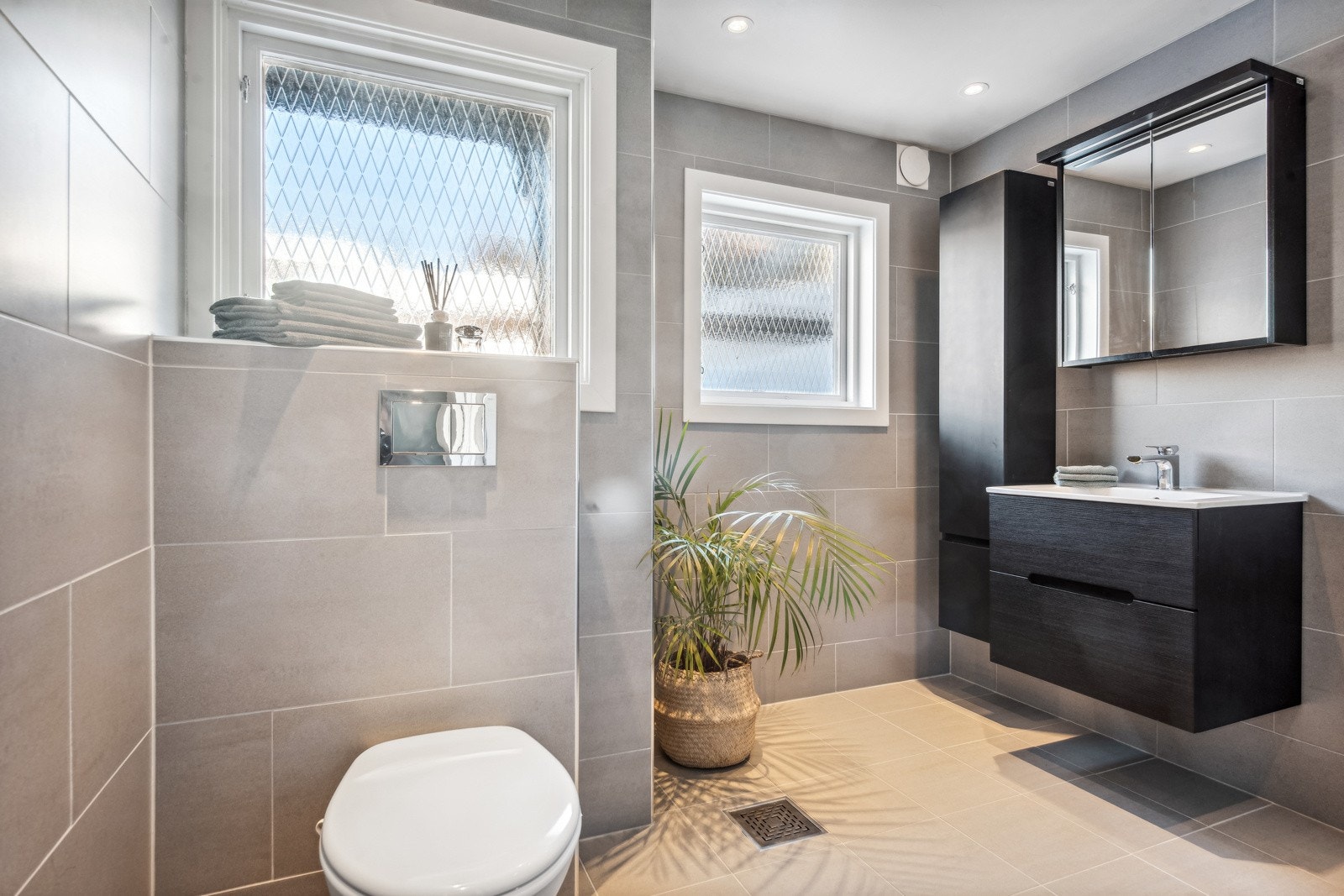 Stilrent og delikat, flislagt bad med gulvvarme Galleribilde