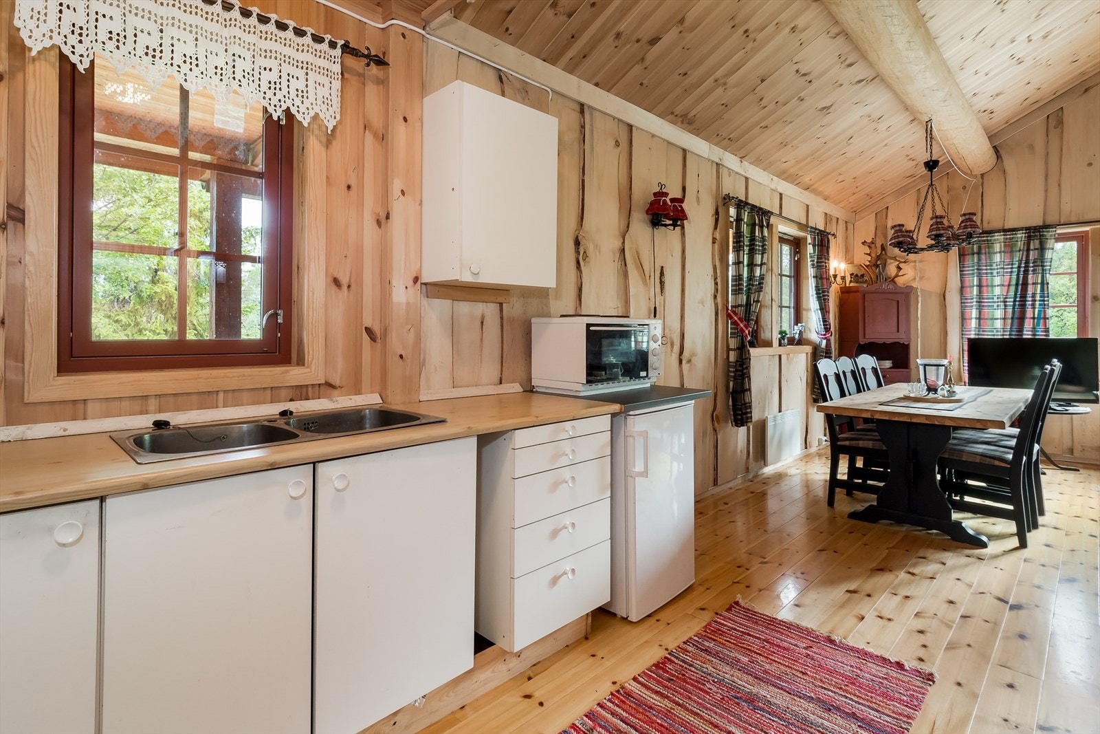 Enkelt hyttekjøkken med glatte, laminerte fronter og laminert benkeplate. Galleribilde