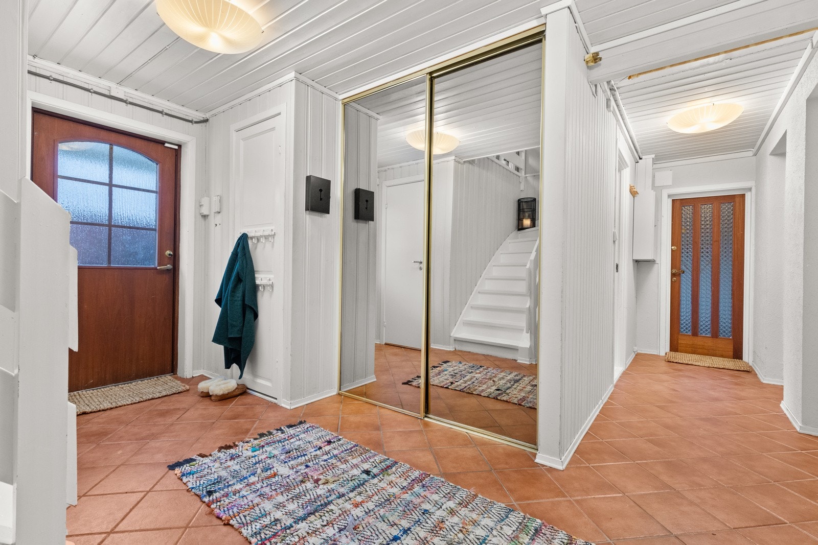 Hovedinngangen med skyvedørsgarderobe og dør synlig inn til carporten. Galleribilde