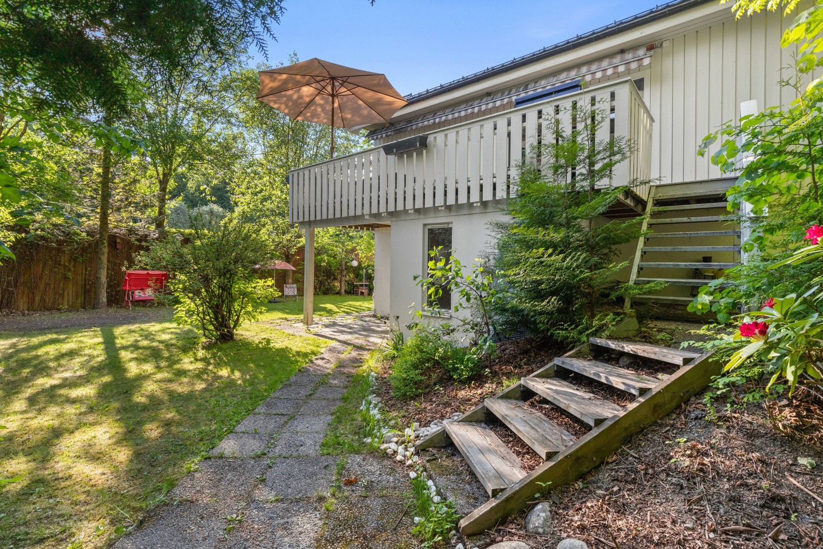 Flott opparbeidet hage med beplantning, trapper og gressplen. Galleribilde