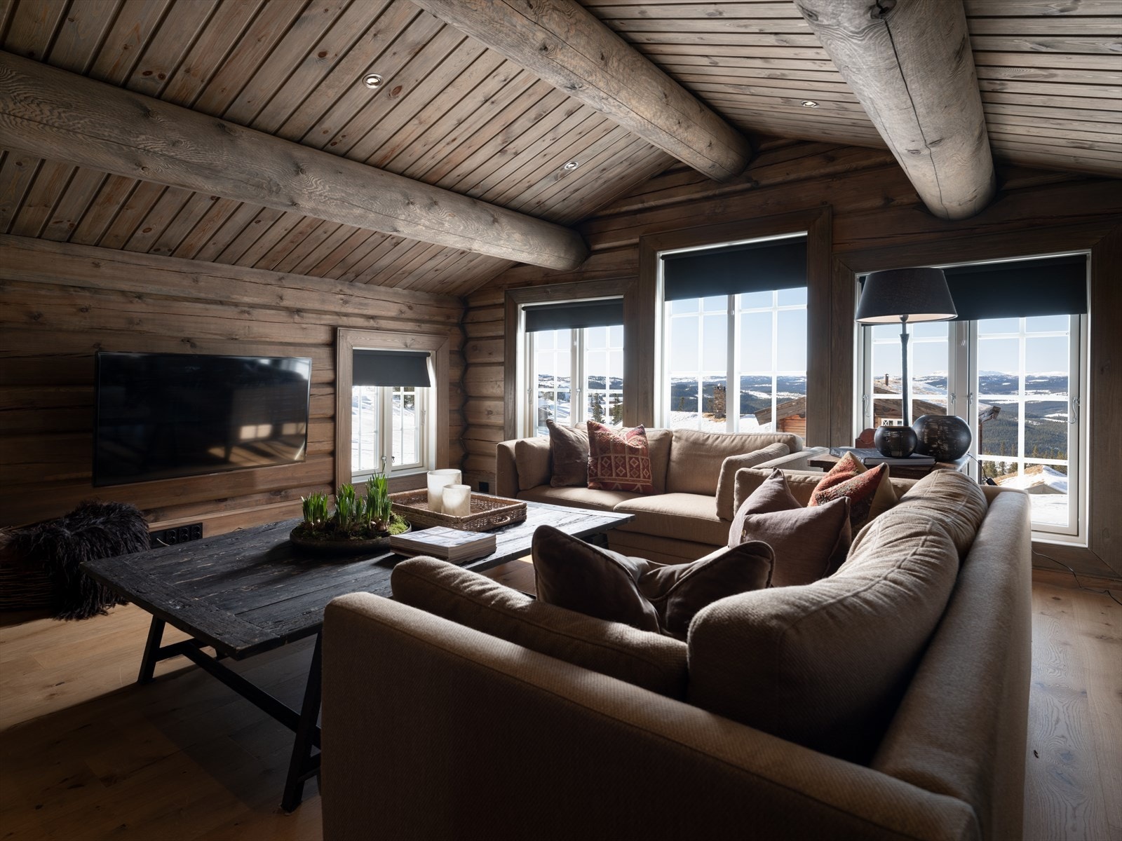 Dette er en romslig stue med store vindusflater som slipper både utsikten og solen inn. Galleribilde