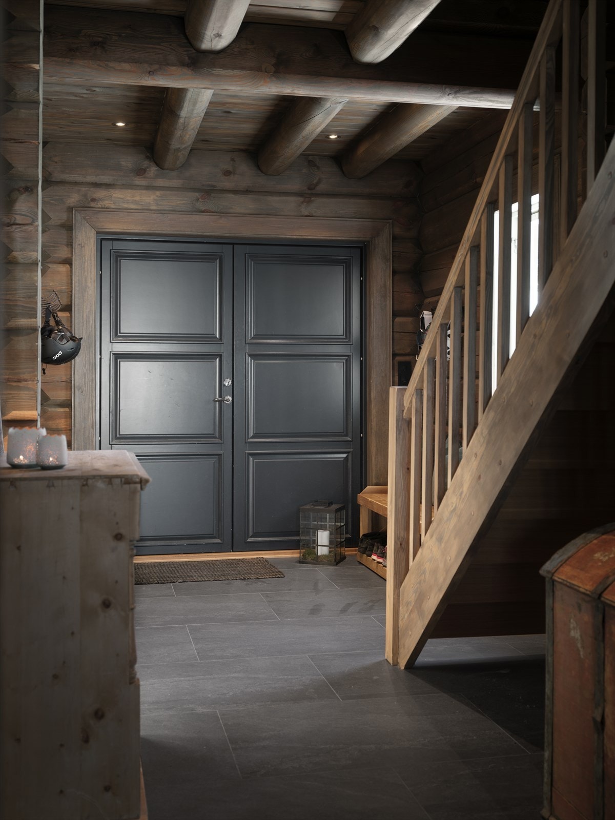 Første møte med hytta er denne lune og innbydende entreen med store gulvfliser og robuste tømmervegger. Galleribilde