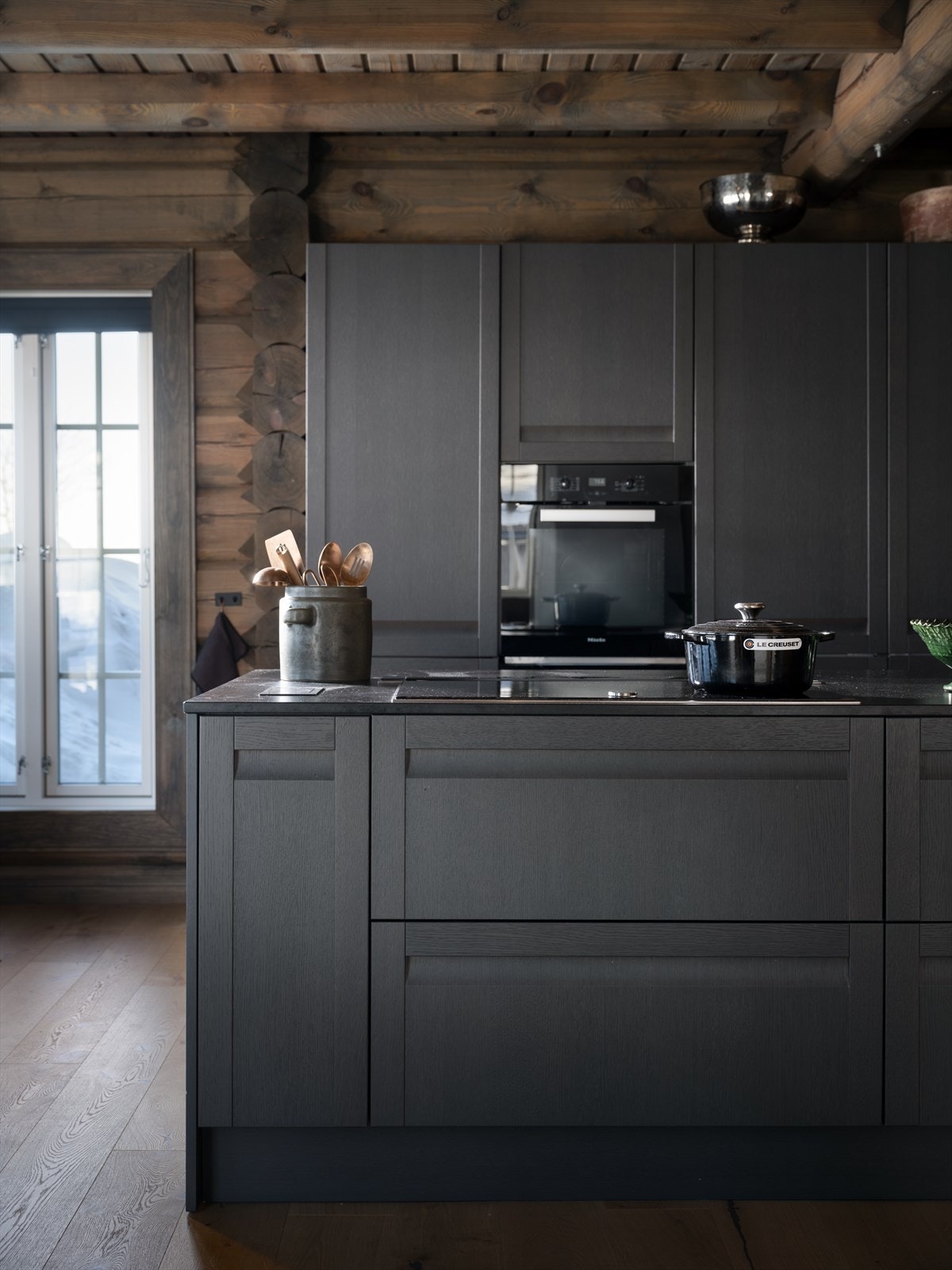 Kjøkkenøya har en bred komfyrtopp, avtrekksvifte med hev og senk funksjon, oppvaskmaskin og en oppvaskkum i rustfritt stål. Galleribilde