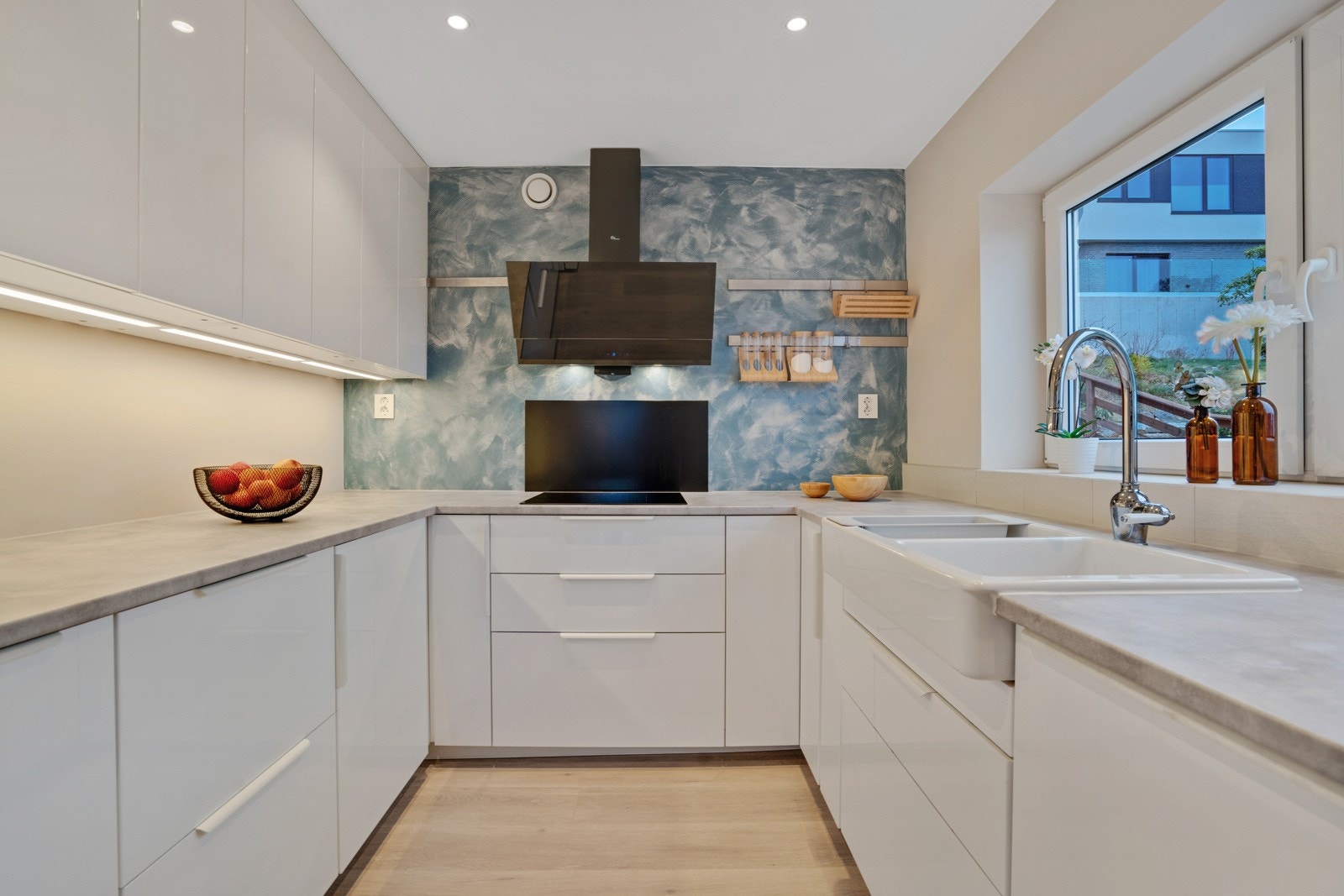 Lyst og pent kjøkken med godt med skap- og benkeplass Galleribilde