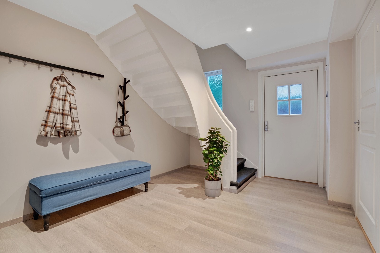 Lys og romslig entré med gode plass til å henge fra seg yttertøyet Galleribilde