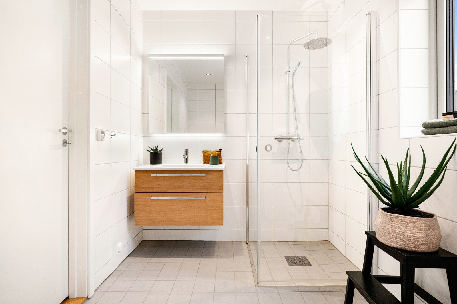 På badet er det vegghengt servantskap og høyskap, dusjhjørne med innfellbare glassdører, vegghengt toalett og opplegg for vaskesøyle Galleribilde