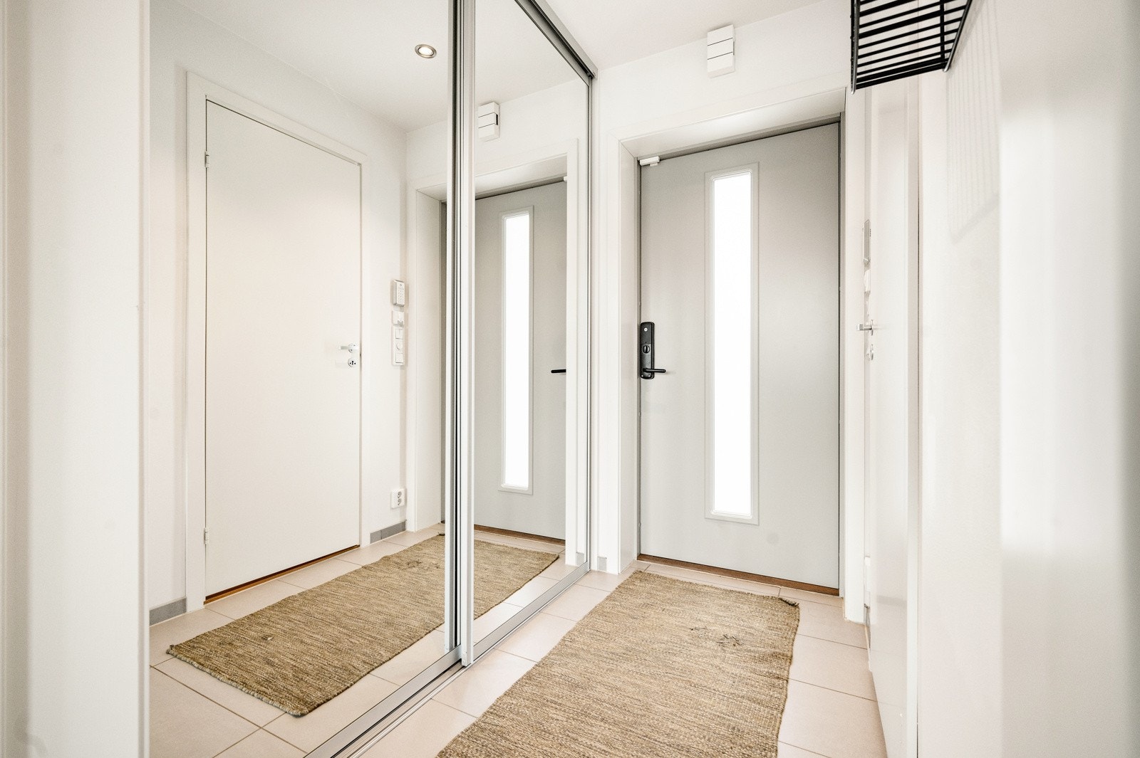 Innbydende entré med skyvedørsgarderobe til yttertøyet Galleribilde