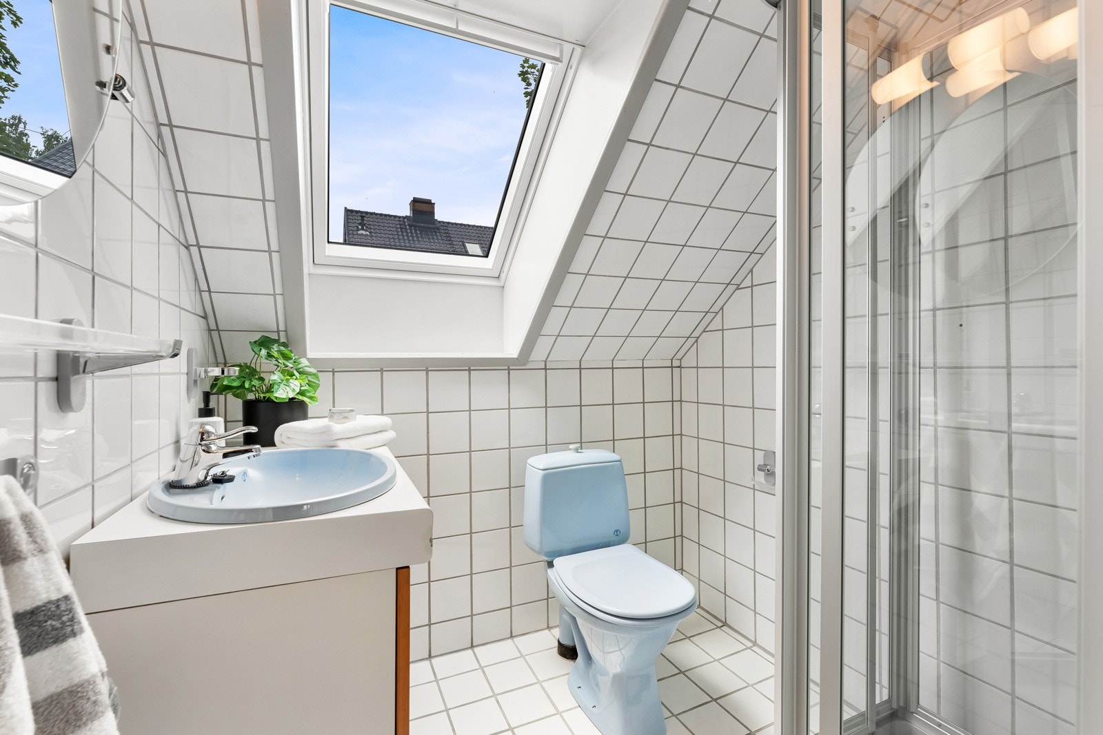 Overetasjen har et pent flislagt bad med servant, gulvstående toalett og dusjkabinett. Galleribilde
