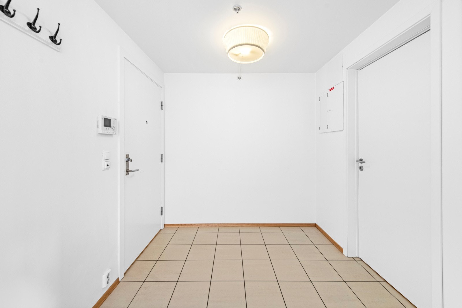 Romslig entré med fliser på gulv. Galleribilde