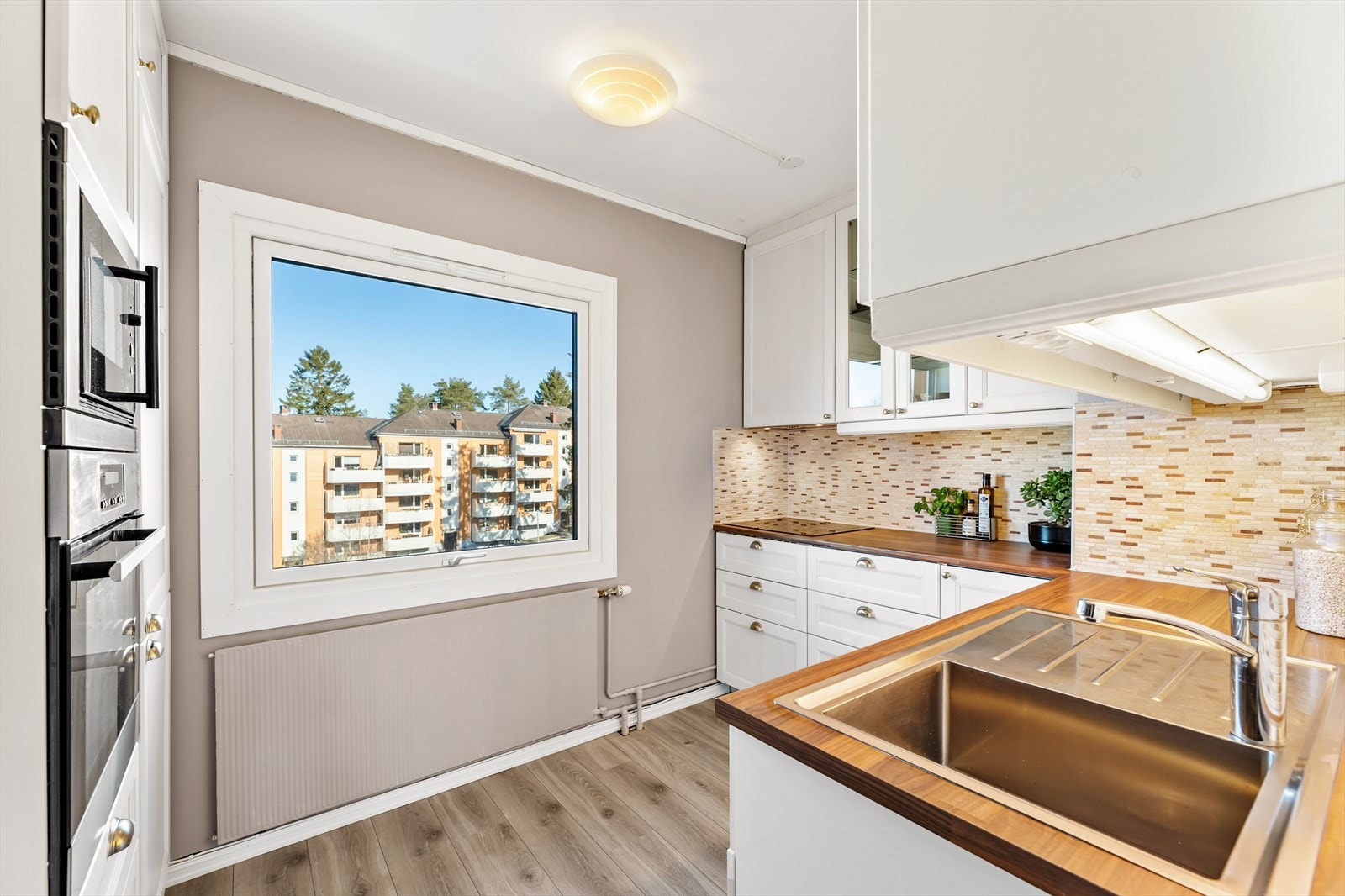 Godt med skap og-benkeplass med fliser mellom over og underskap. Galleribilde