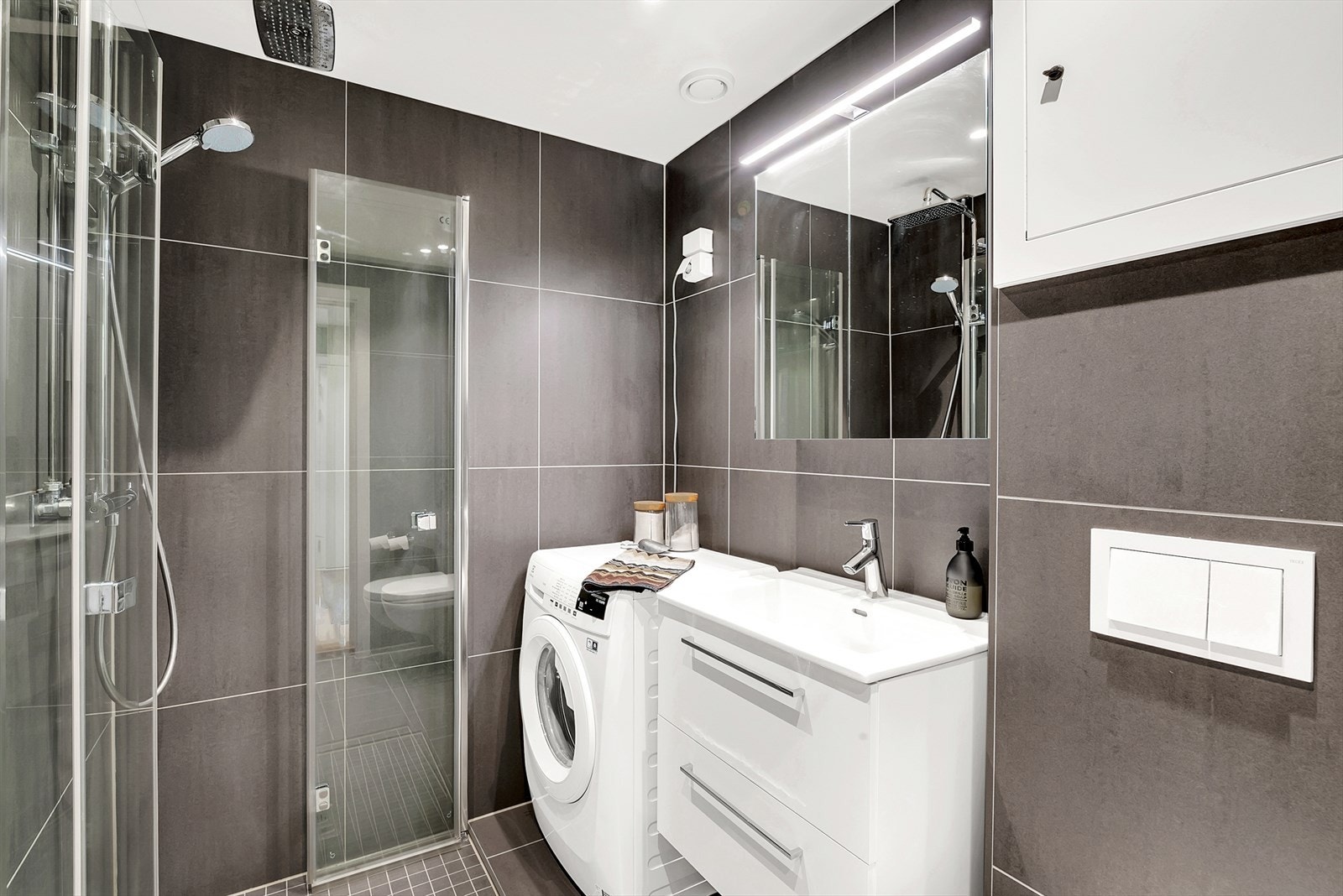 Lekkert nyere bad med fliser på gulv og vegger, malt tak med downlights. Bad/wc ble rehabilitert i regi av borettslaget i januar 2021 med nye overflater, membranløsninger, sluk, røropplegg, varmekabler og sanitærutstyr. Galleribilde
