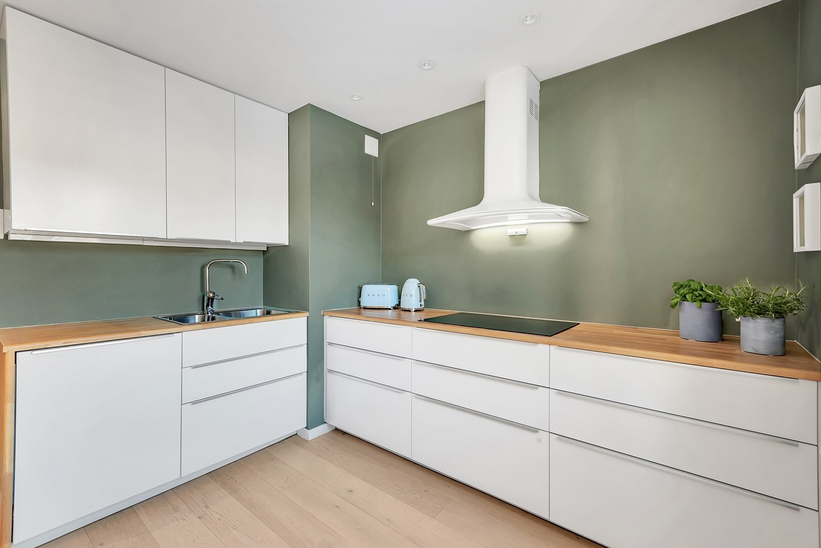 Kjøkkeninnredningen består av hvite slette fronter, heltre eik benkeplate, oppvaskkum, fritthengende ventilator og integrerte hvitevarer som koketopp, stekeovn, oppvaskmaskin, mikroovn og kjøl-/fryseskap. Galleribilde