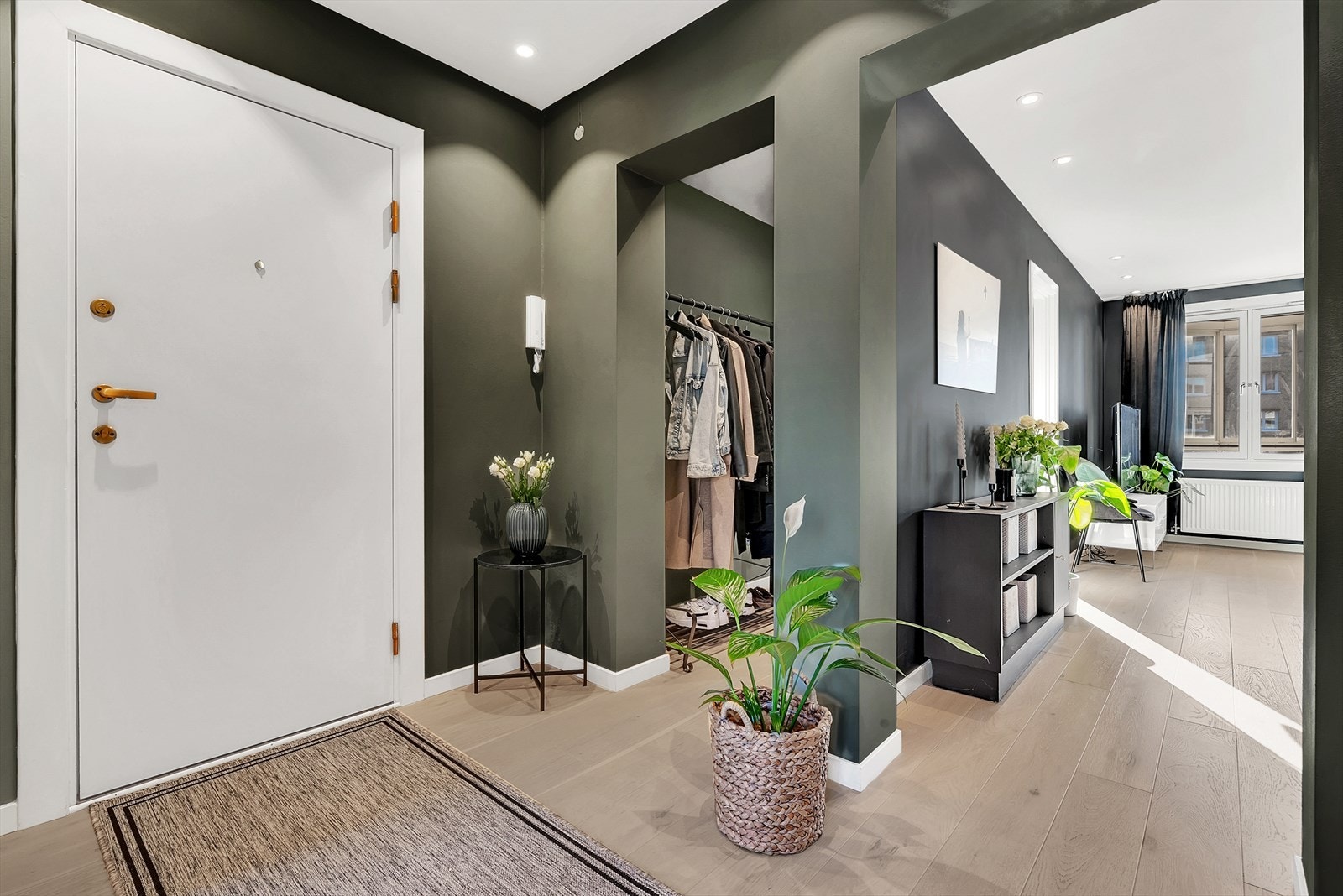 Innbydende entré med parkett på gulv, malte slette vegger og malt tak med downlights. Direkte adkomst til en flott og praktisk garderobe. Galleribilde