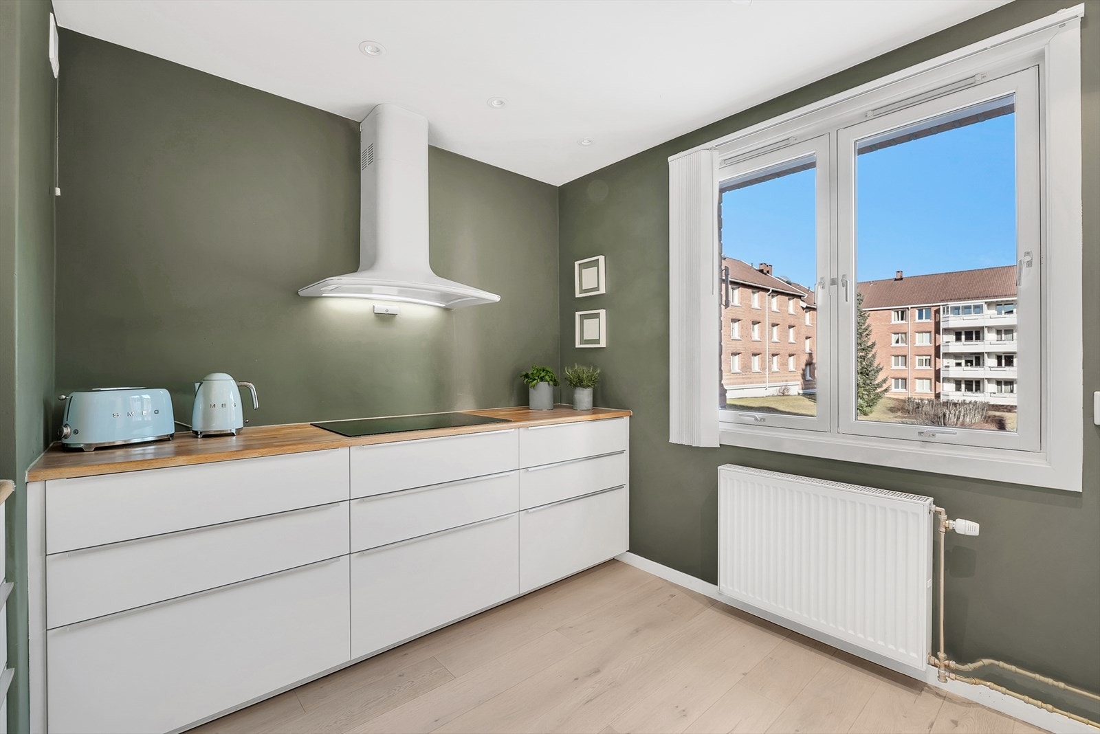 Flott og godt utnyttet kjøkken fra 2015 med parkett på gulv, malte slette vegger og malt tak med downlights. Galleribilde