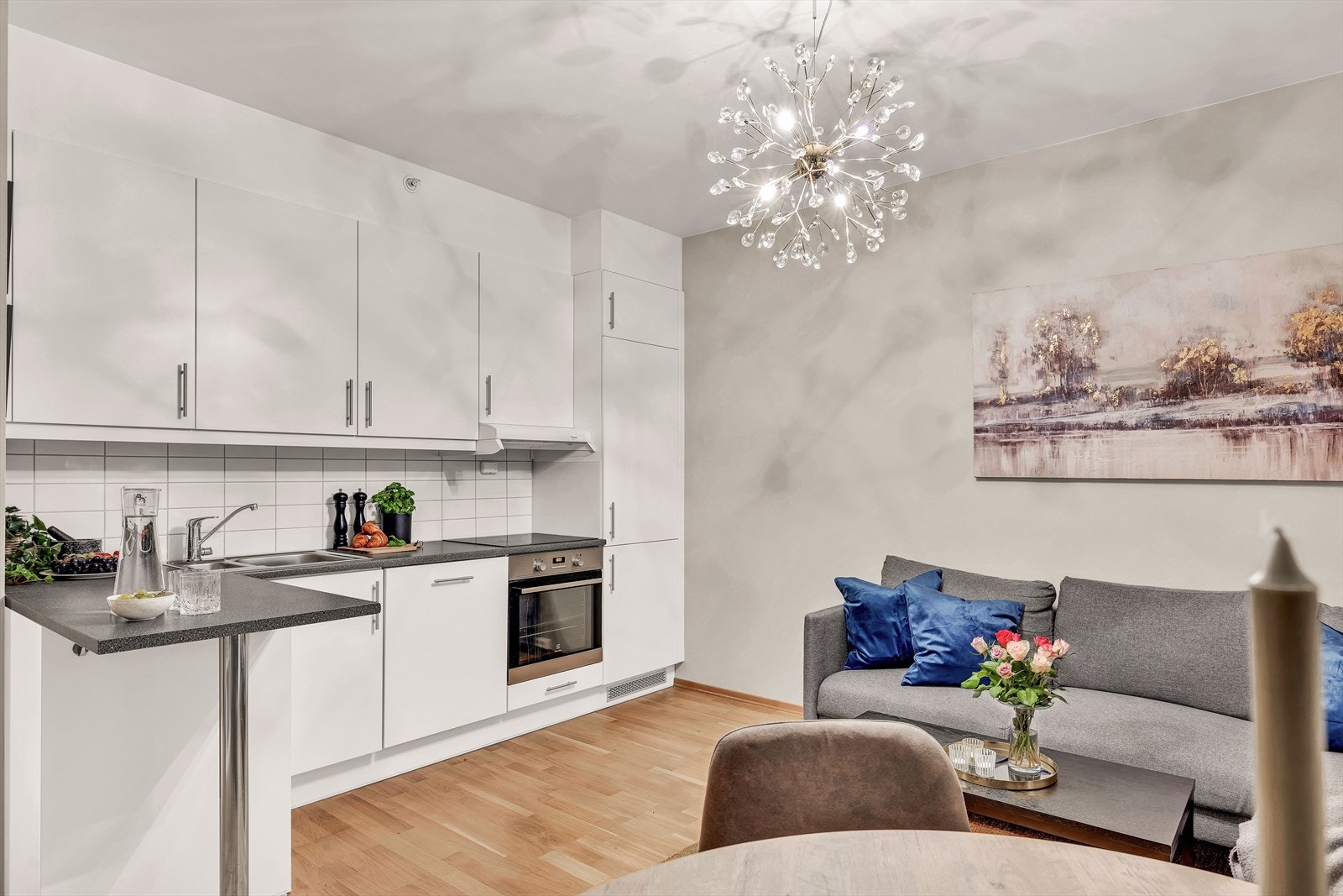 Kjøkkenet har glatte fronter, laminat benkeplate med nedfelt vask- og skyllekum samt fliser og belysning over benkeplaten. Galleribilde