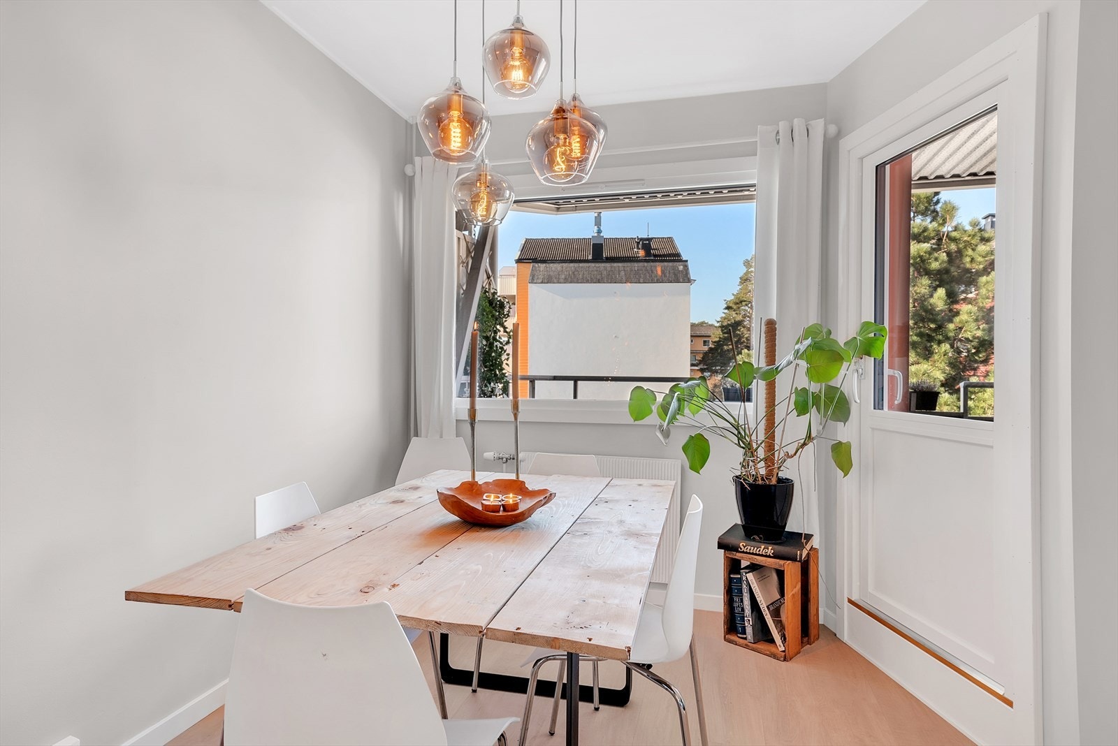 Romslig stue med laminat på gulv, malte slette vegger og en vegg med fliser samt malt tak. Her er det god plass for både sofagruppe og spisegruppe. Galleribilde