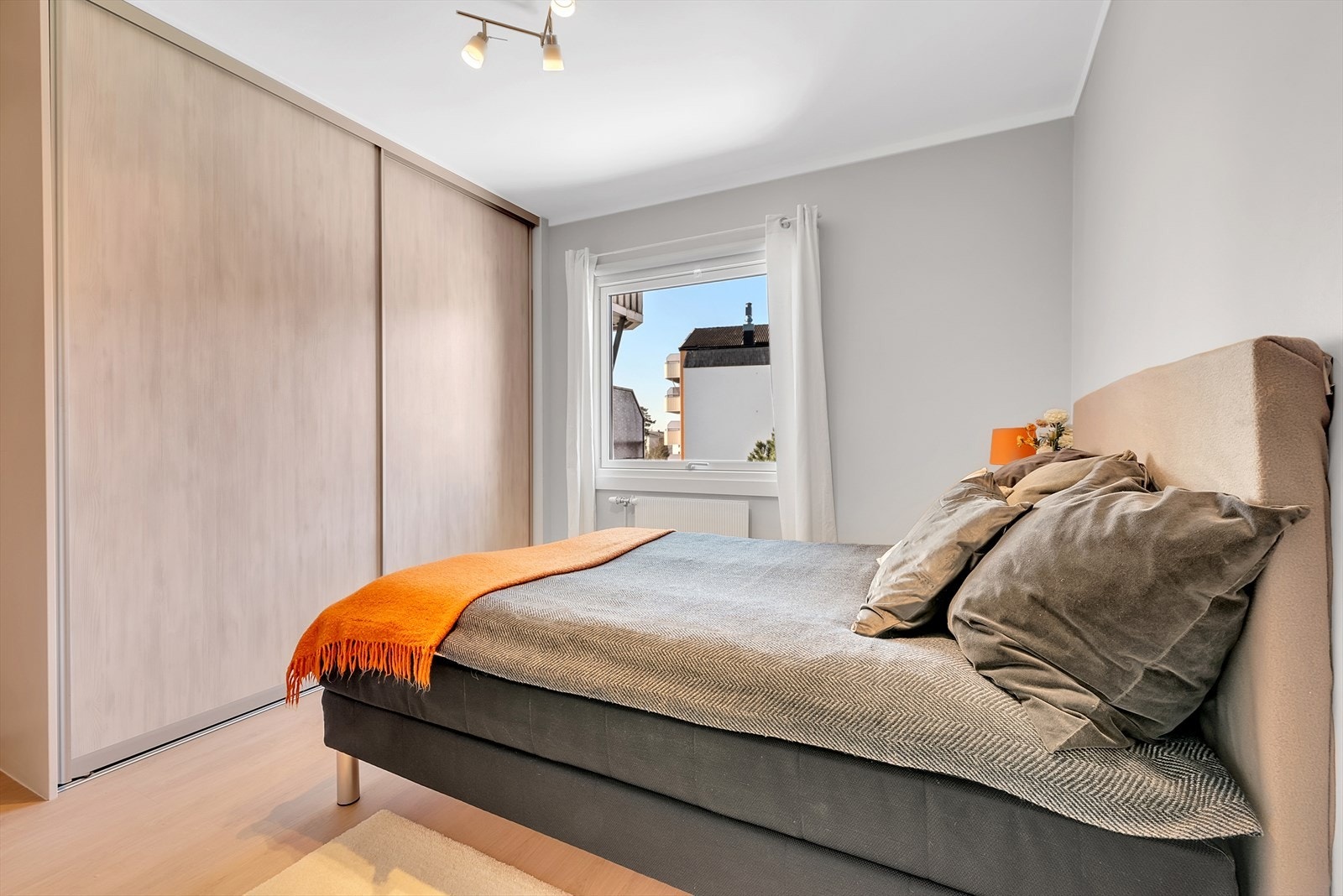 Hovedsoverom med laminat på gulv, malte slette vegger og malt tak. Her er det montert en stor og praktisk plassbygd skyvedørsgarderobe. Galleribilde