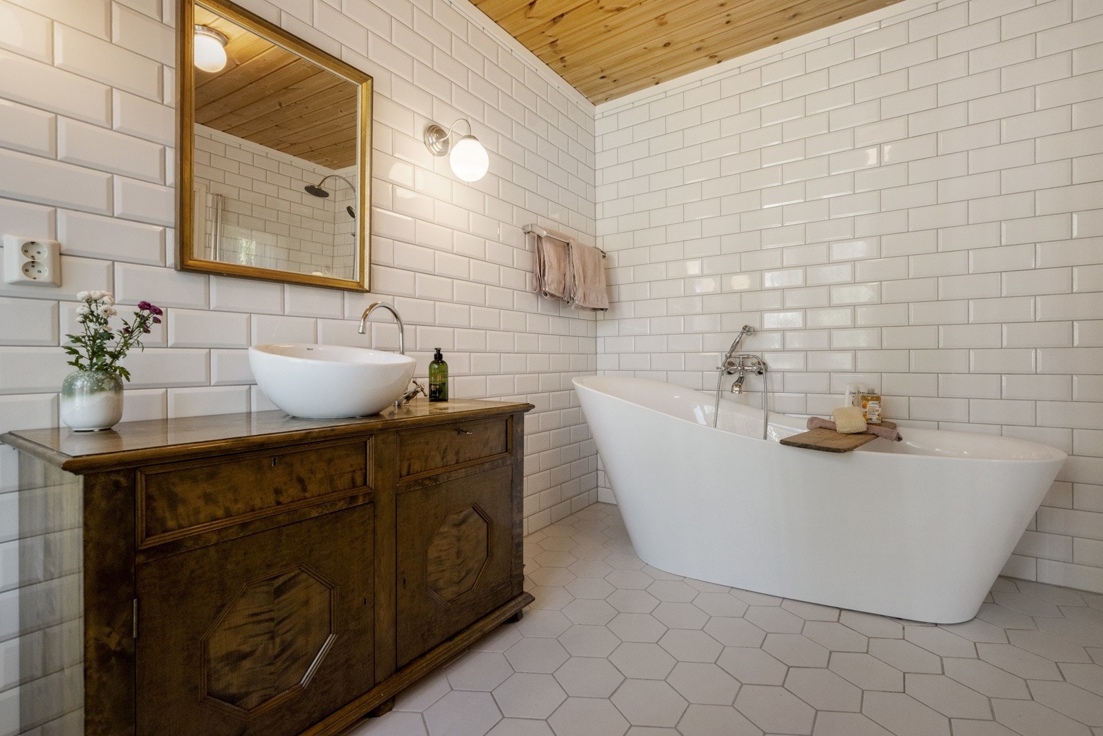 Badet er innredet med dusjsone med foldedører, badekar, servant med skap og WC. Galleribilde