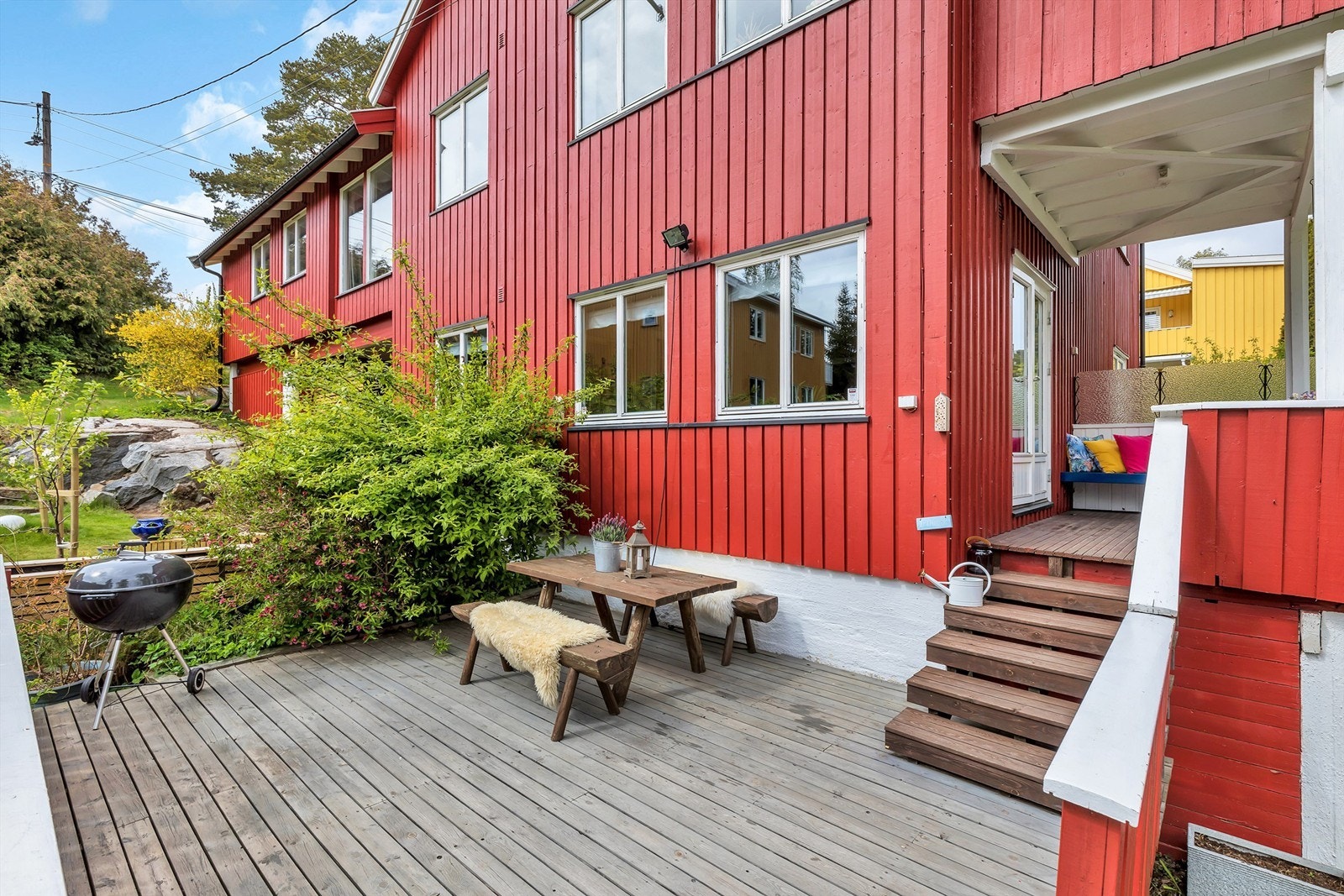 Meget barnevennlig og solrik hage opparbeidet med stor usjenert sydvendt terrasse, plen og beplantning. Galleribilde