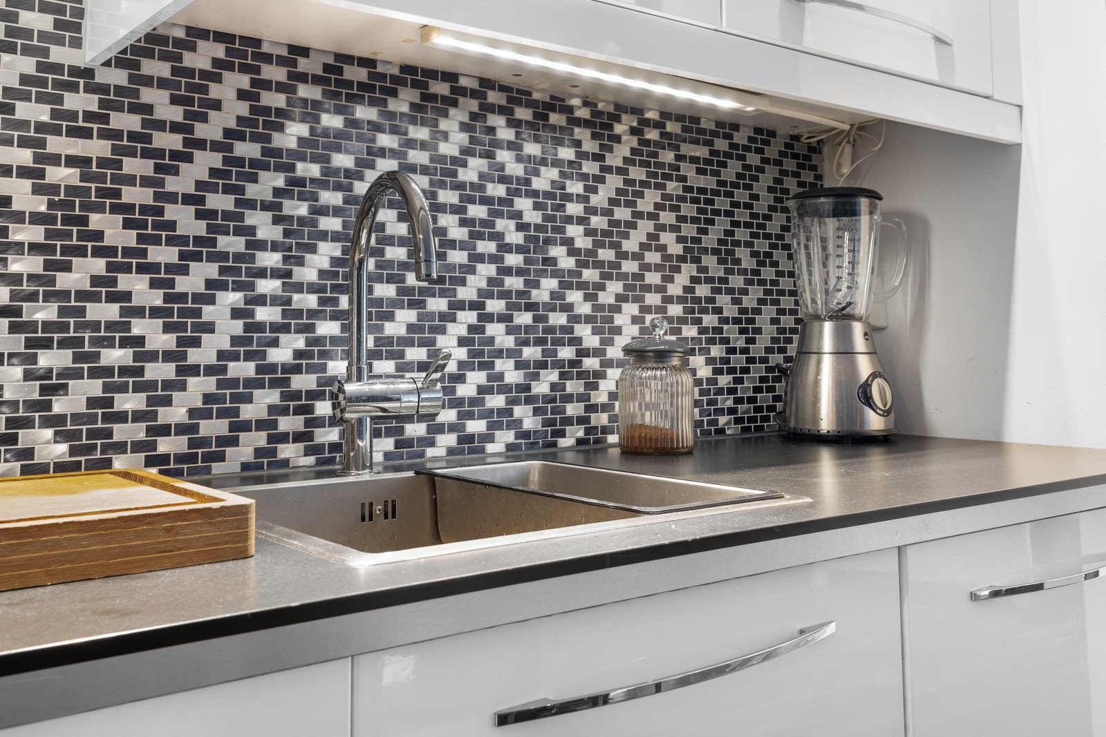 Kjøkkeninnredningen har benkeplater i laminat og stor oppvaskkum i stål. Galleribilde