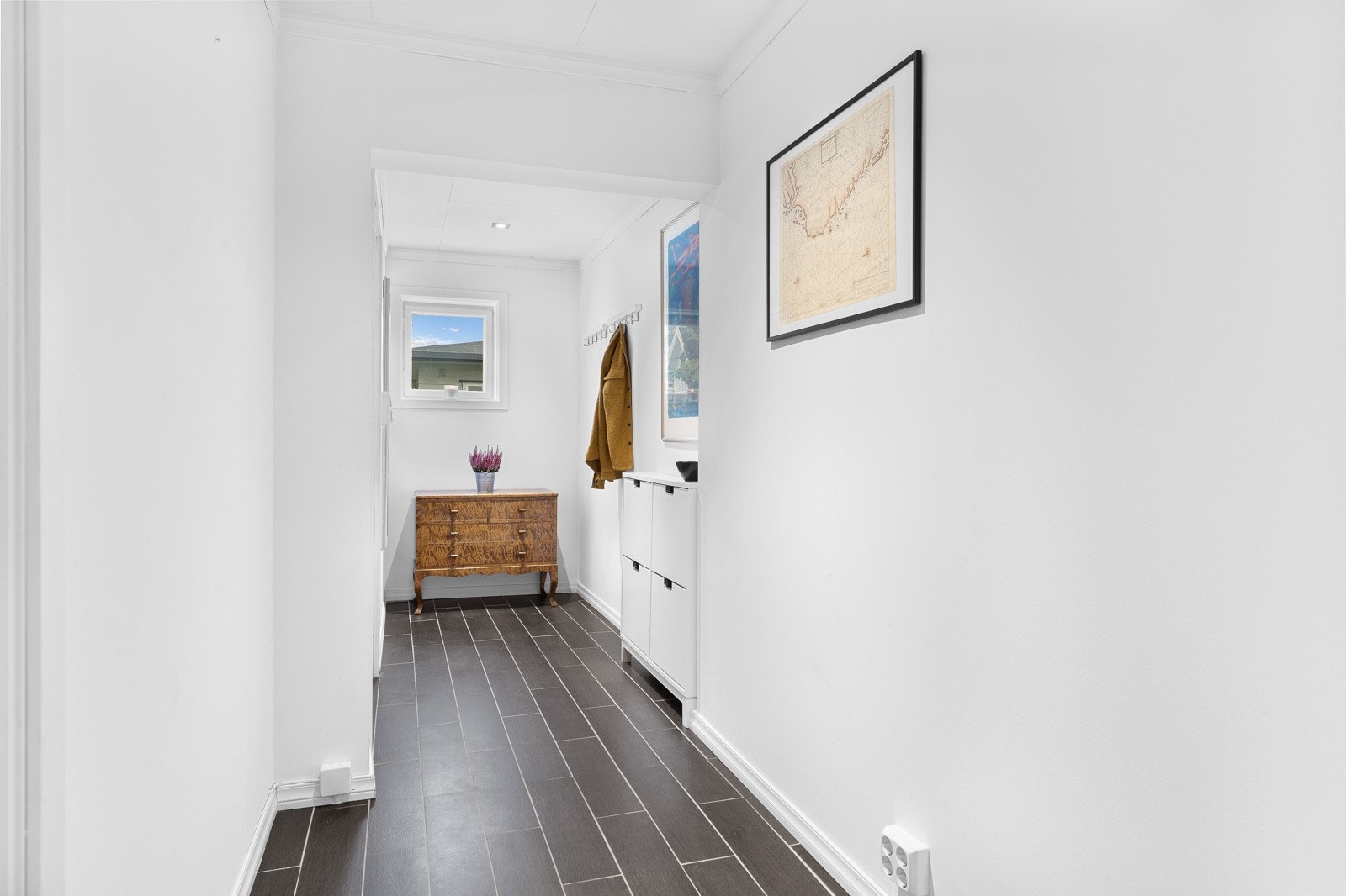 Lysmalt avlang entré/gang med fliser på gulvet med varmekabler og downlights i himling. Galleribilde