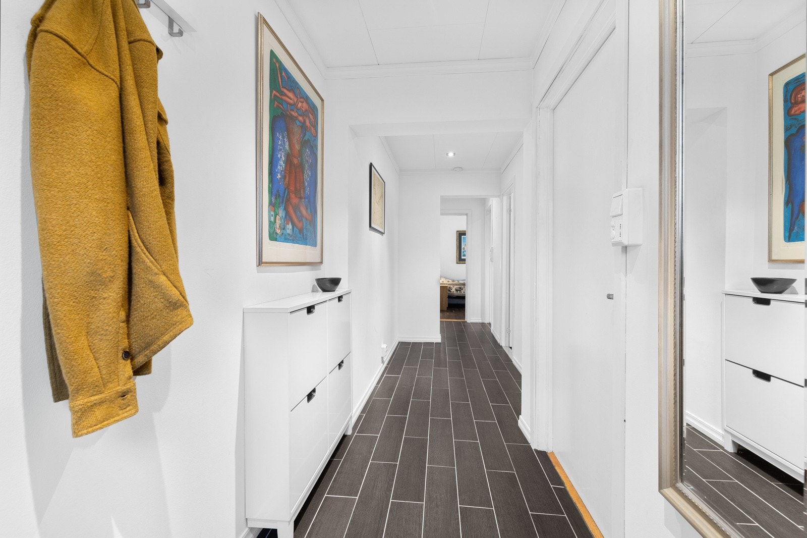 Langs vegg er det montert skoskap og knaggrekke, og det er plass til ytterligere entrémøblement som kommode, skohylle og konsollbord. Galleribilde